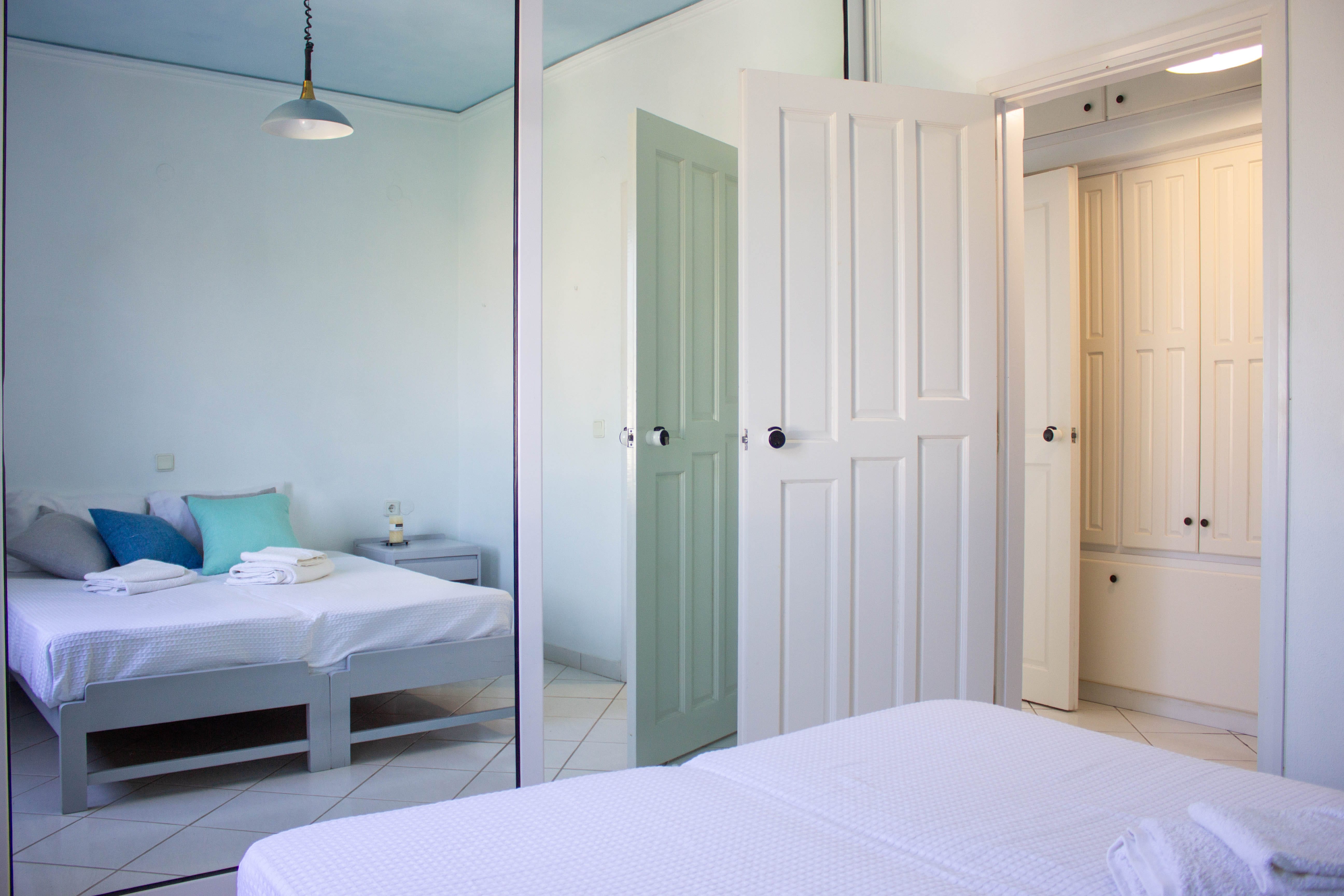 a room with white beds and white doors