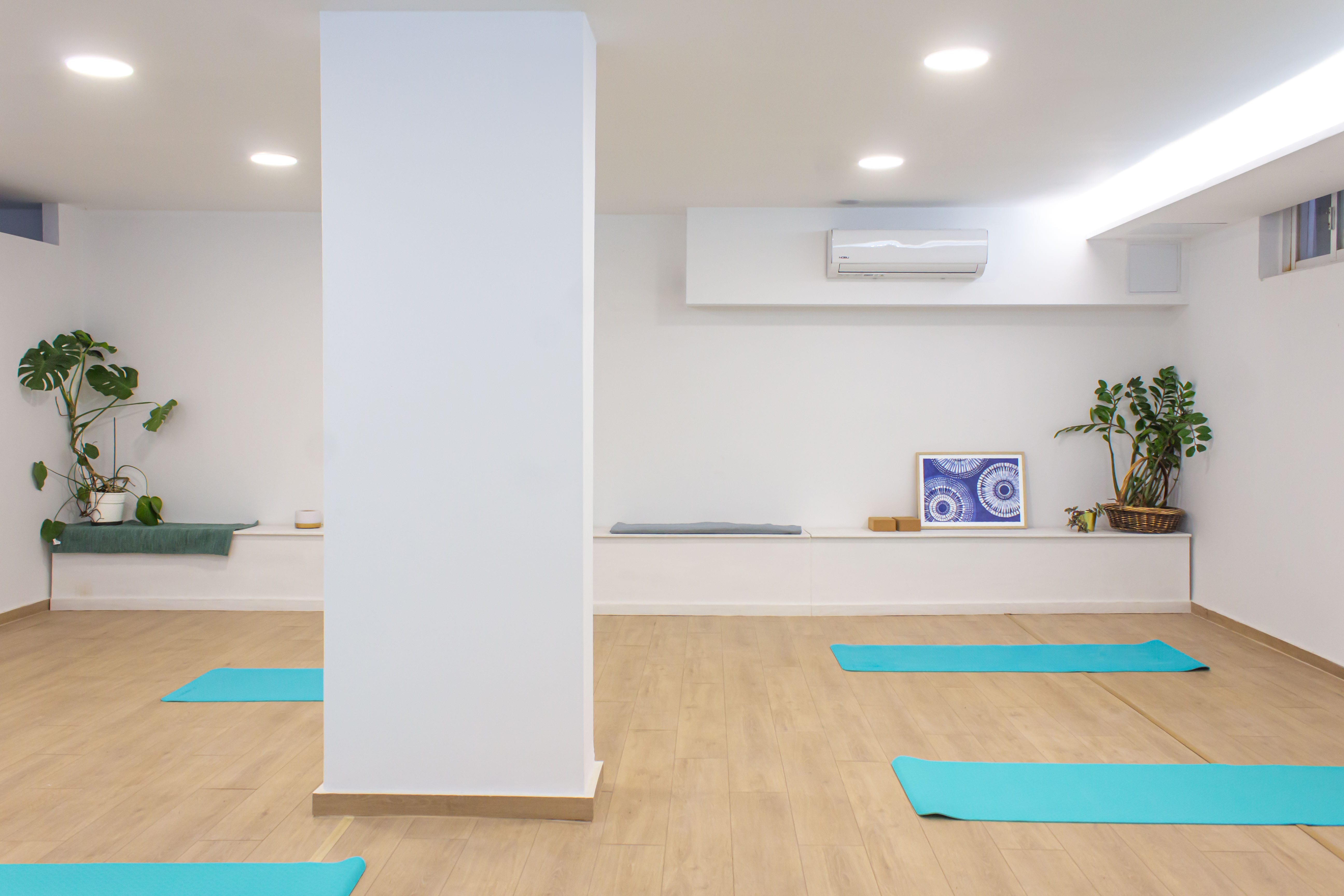 a room with a white pillar and a white wall with a picture on it