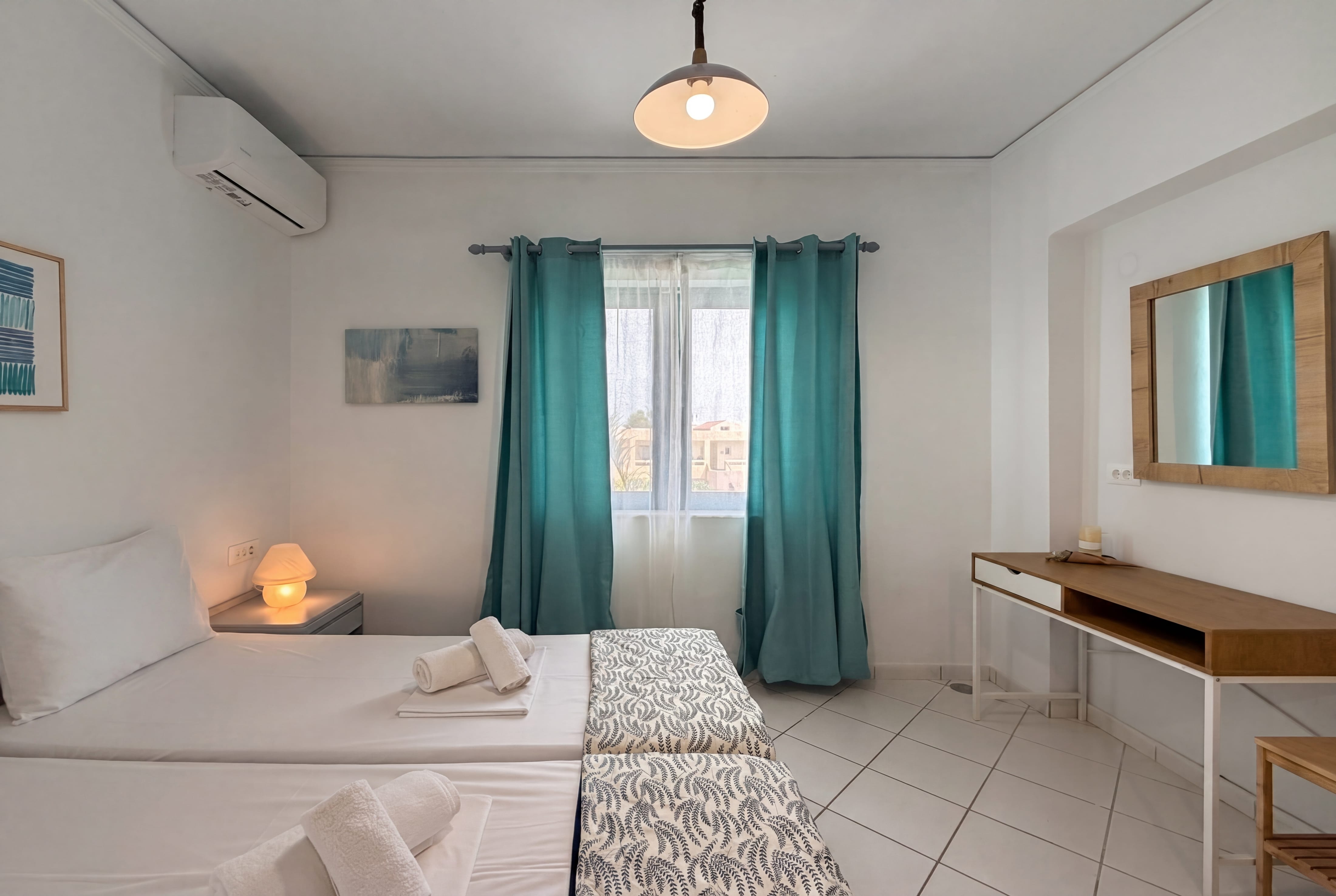 a room with two beds and a lamp