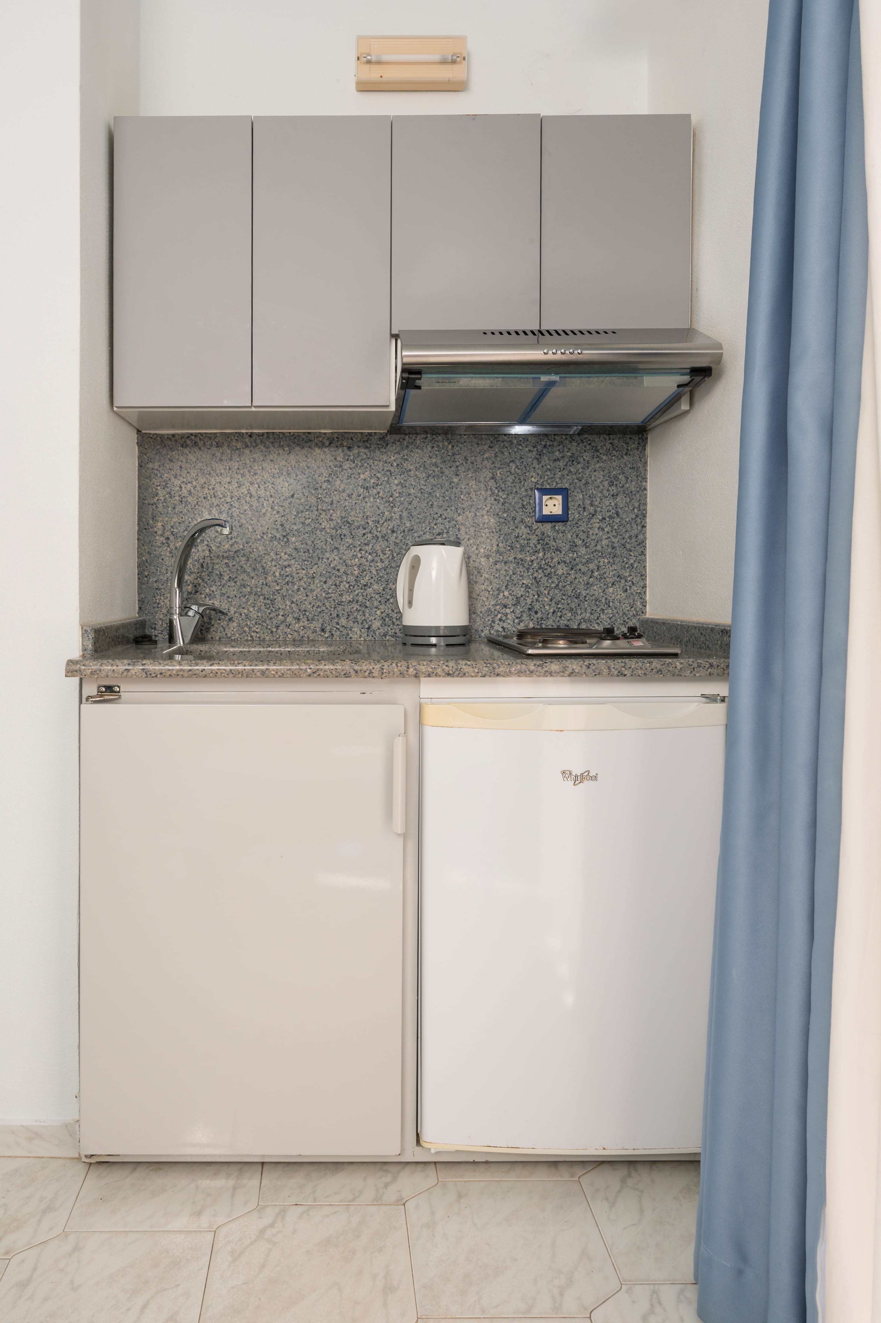 a small kitchen with a small refrigerator