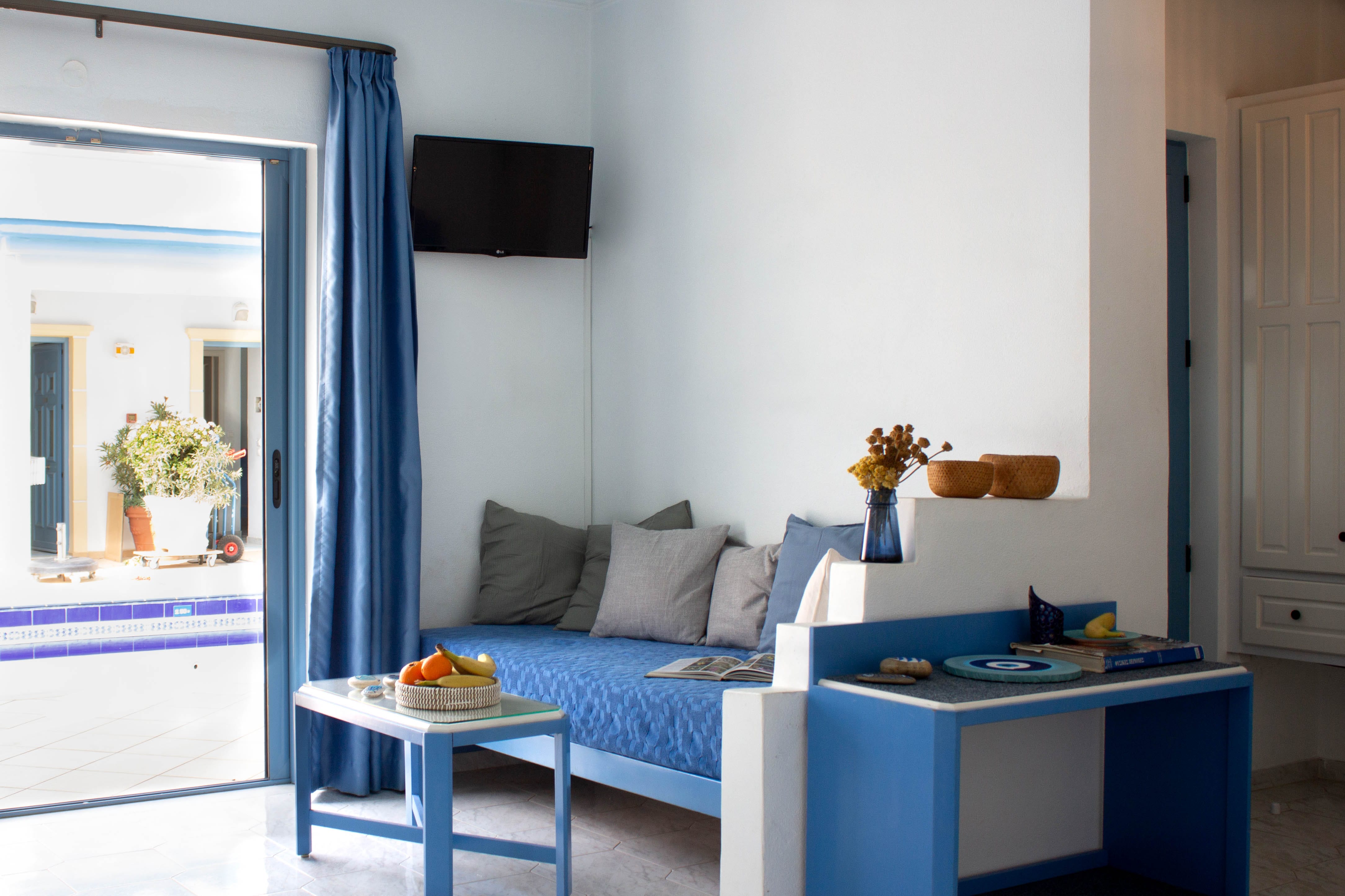 a room with a blue couch and a table with a blue curtain