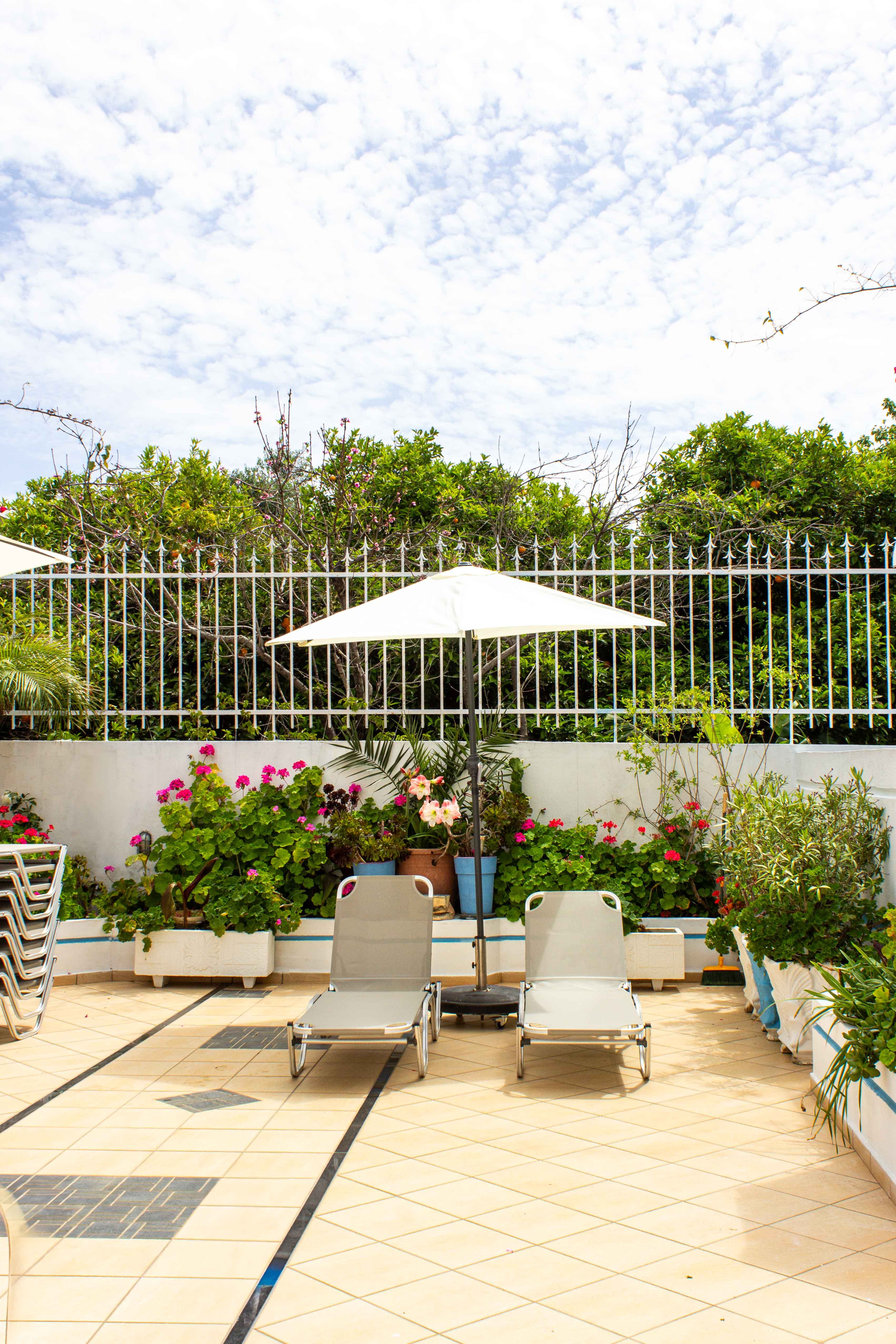 a patio with chairs and an umbrella