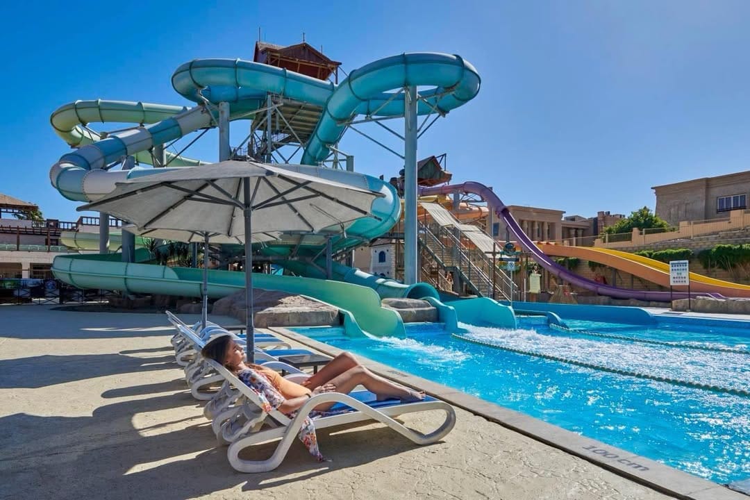 a person sitting in a lounge chair by a pool