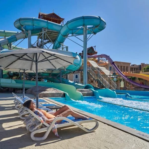 a person sitting in a lounge chair by a pool