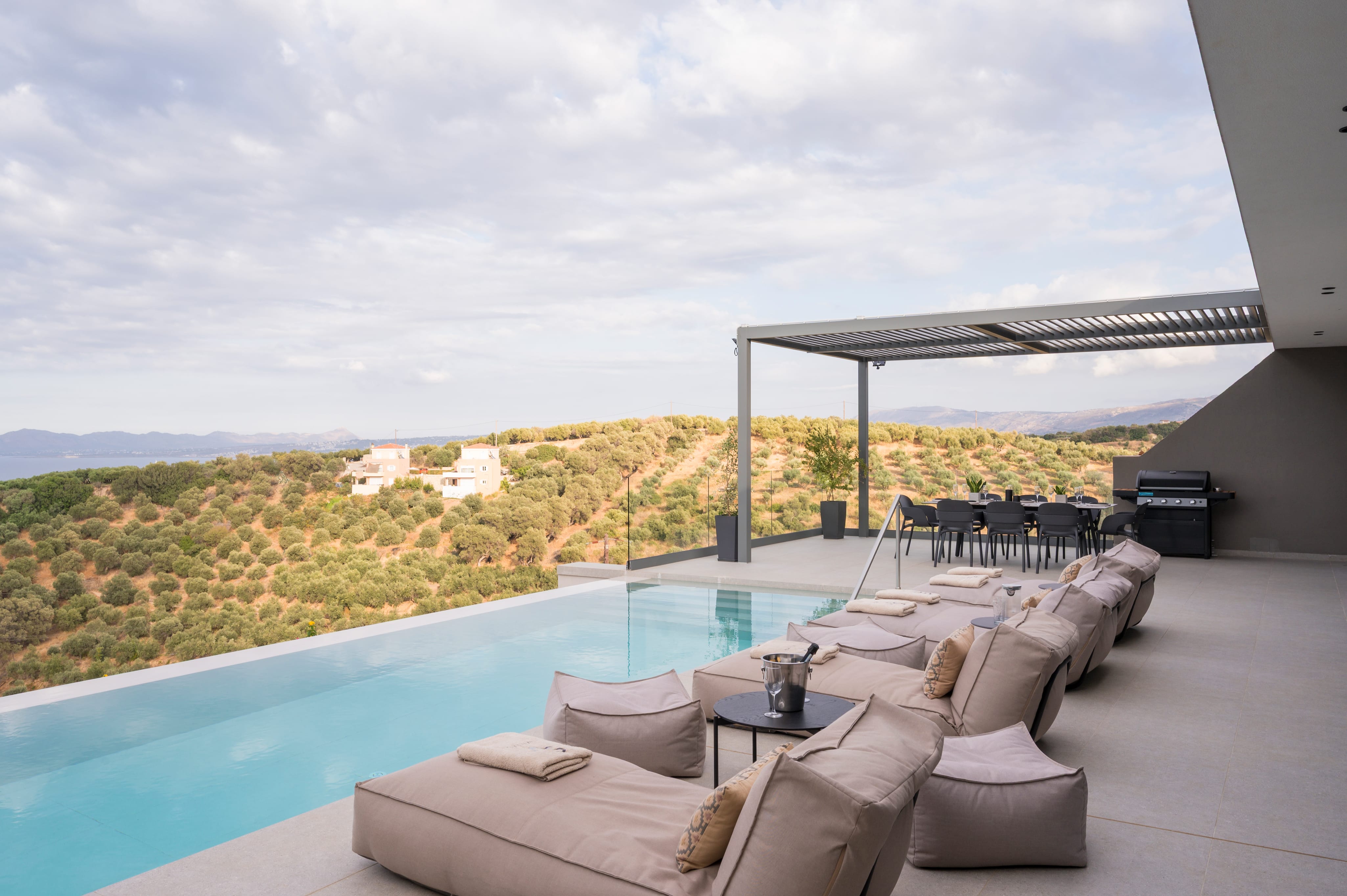 a large pool with a lounge chair and a view of a field