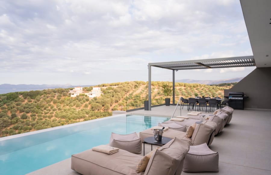 a large pool with a lounge chair and a view of a field