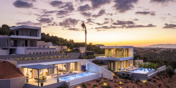 a building with a pool and a sunset in the background