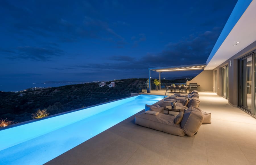 a deck with a pool and a view of the ocean