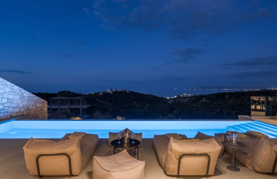 a pool with a view of a city and mountains in the background