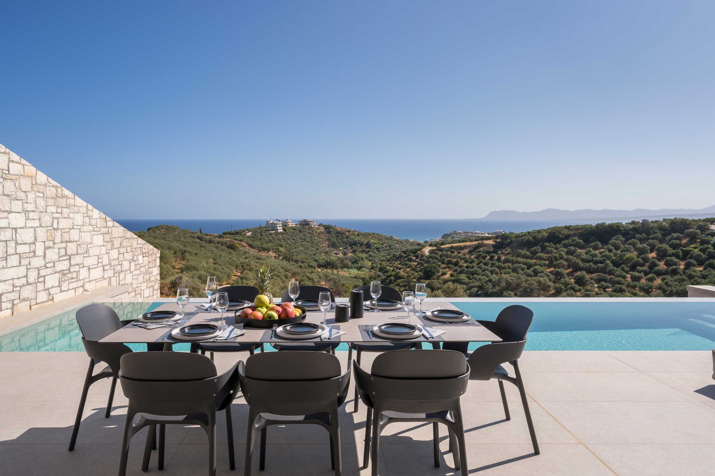 a table with chairs and a pool in the background