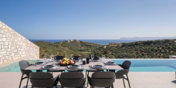 a table with chairs and a pool in the background