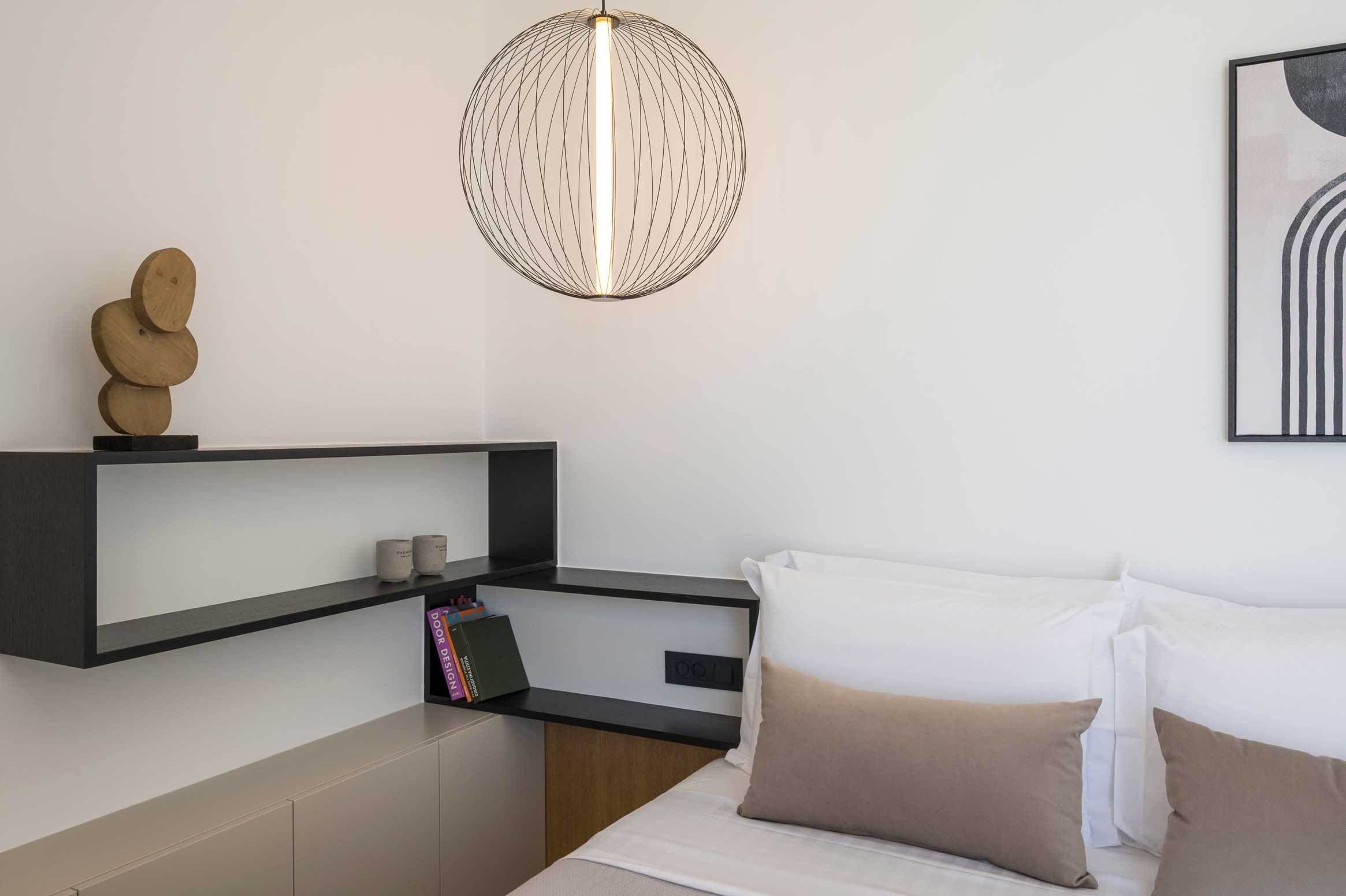 a room with a bed and a desk with a lamp on it