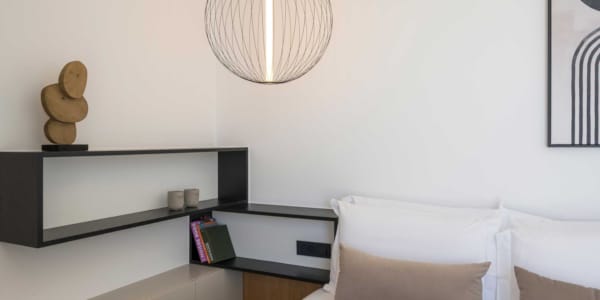 a room with a bed and a desk with a lamp on it