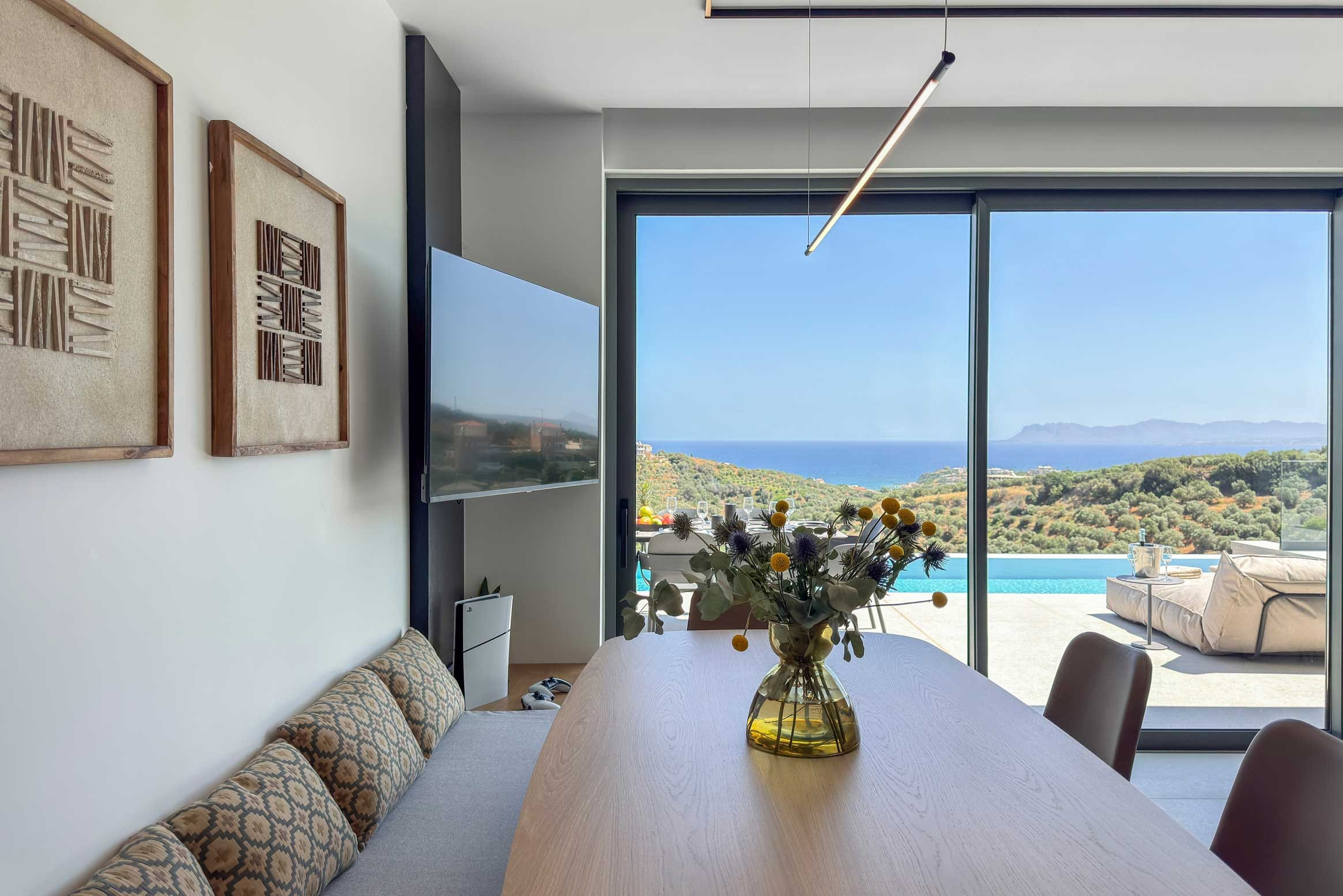 a table with a vase of flowers on it in a room with a window and a body of