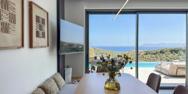 a table with a vase of flowers on it in a room with a window and a body of