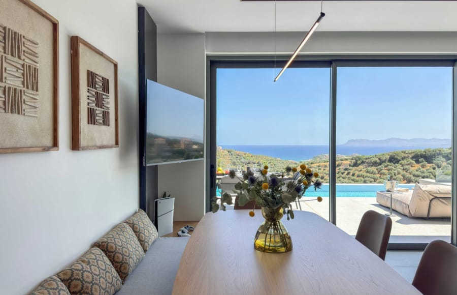 a table with a vase of flowers on it in a room with a window and a body of