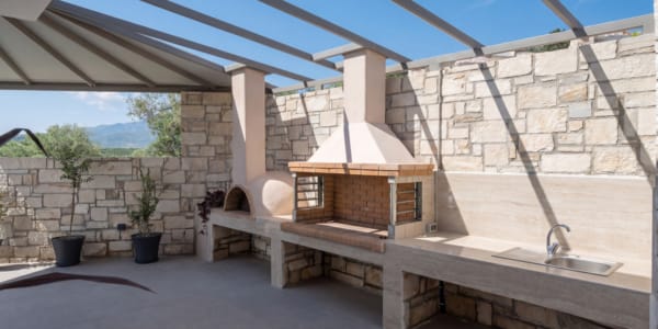 a stone patio with a fireplace