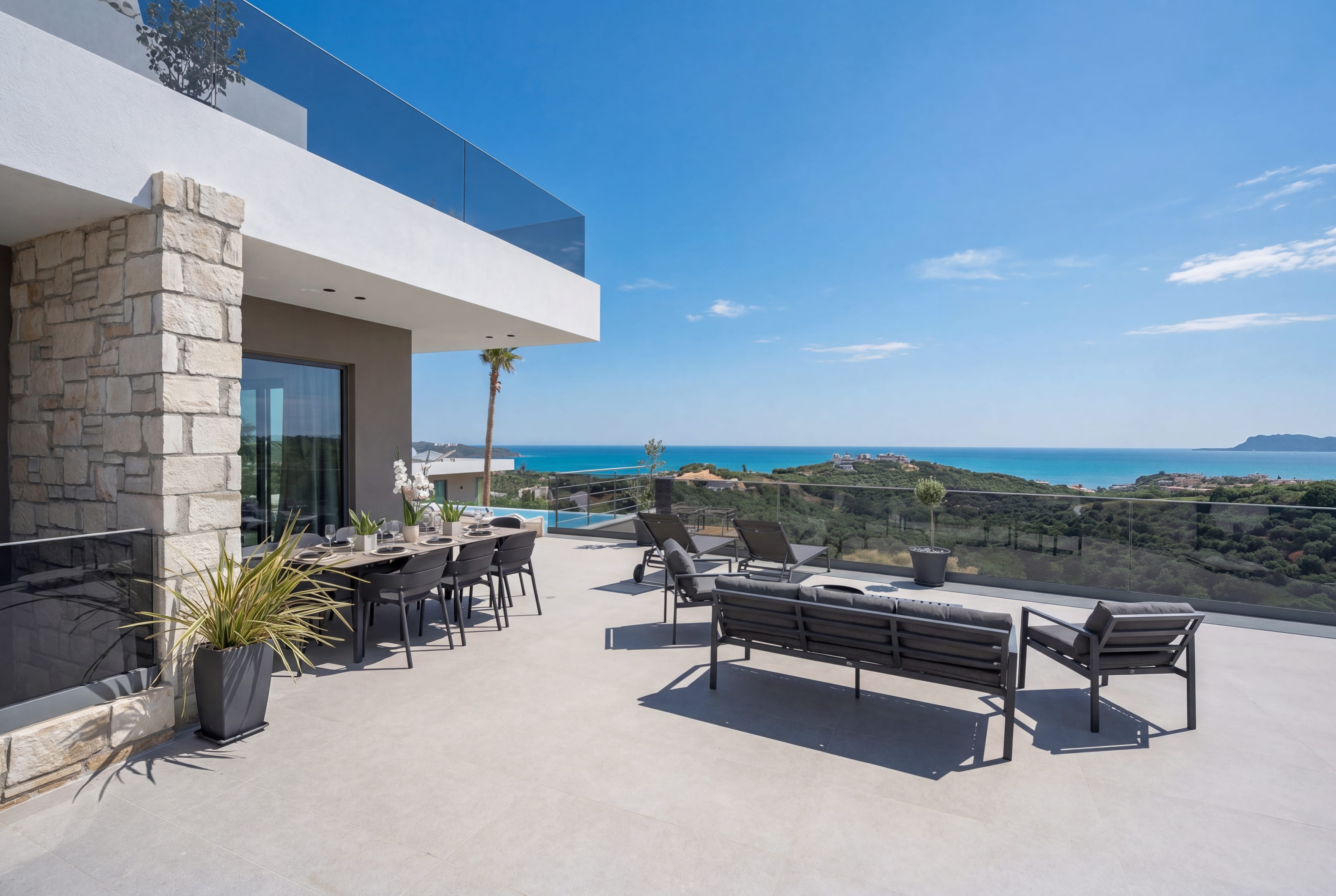 a patio with chairs and a balcony overlooking the ocean