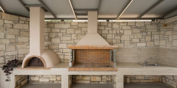 a stone patio with a brick oven