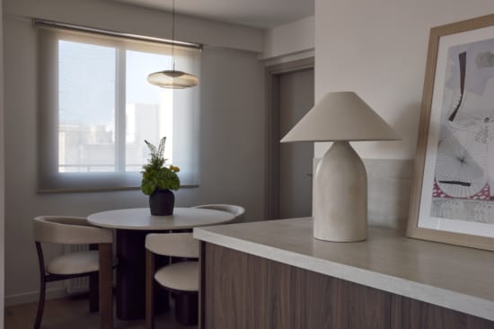 a table with a lamp and chairs