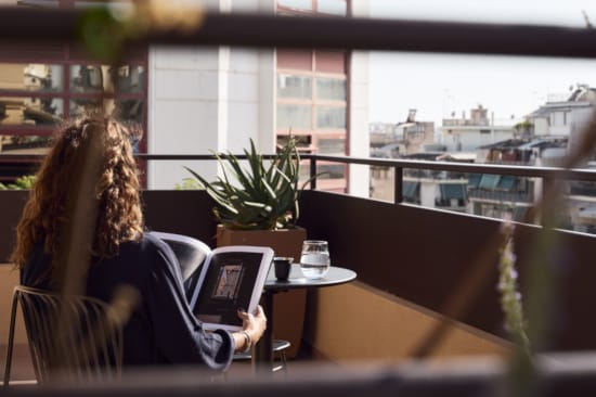 a person sitting at a table with a laptop and a plant