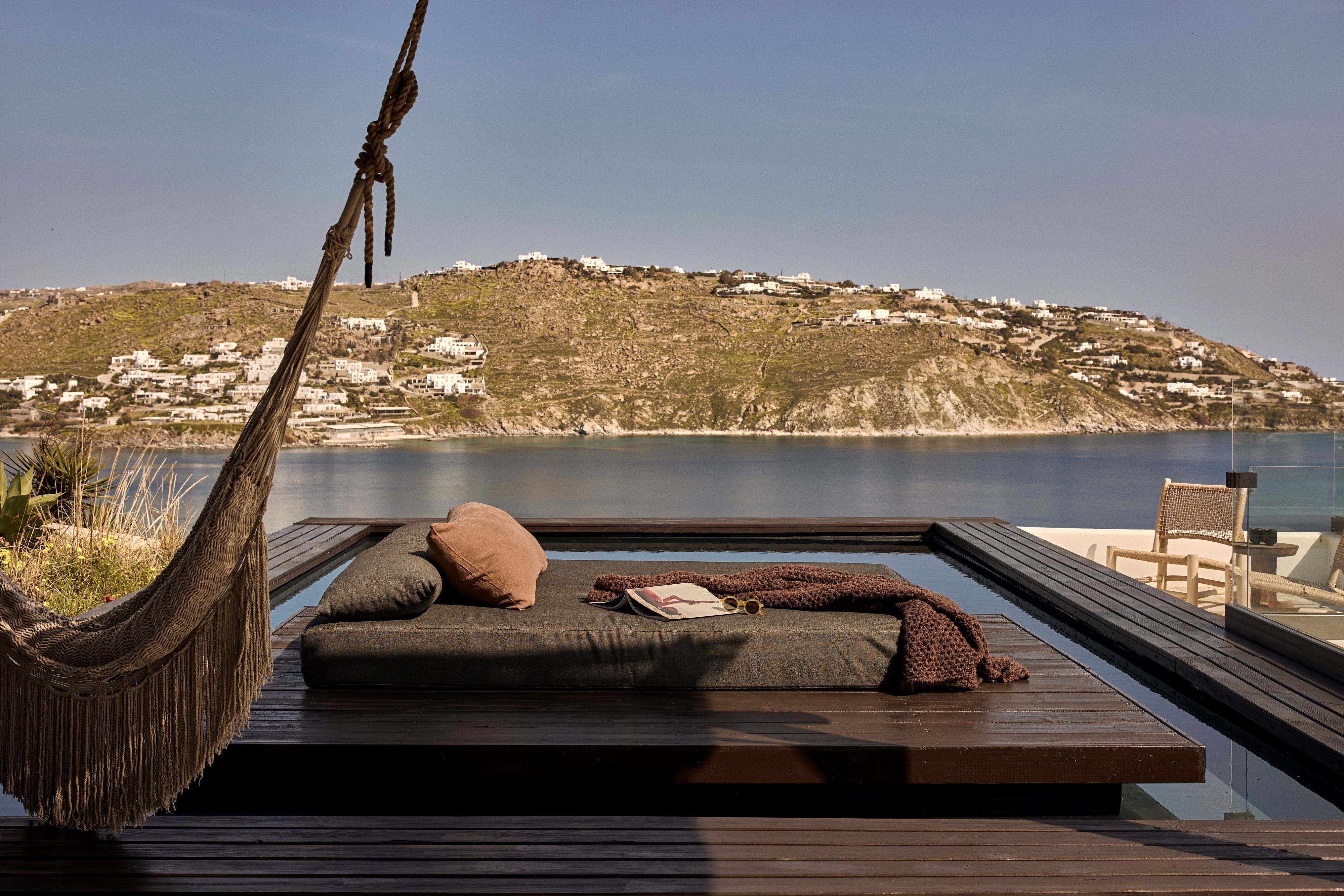 a deck with a table and a body of water in the background