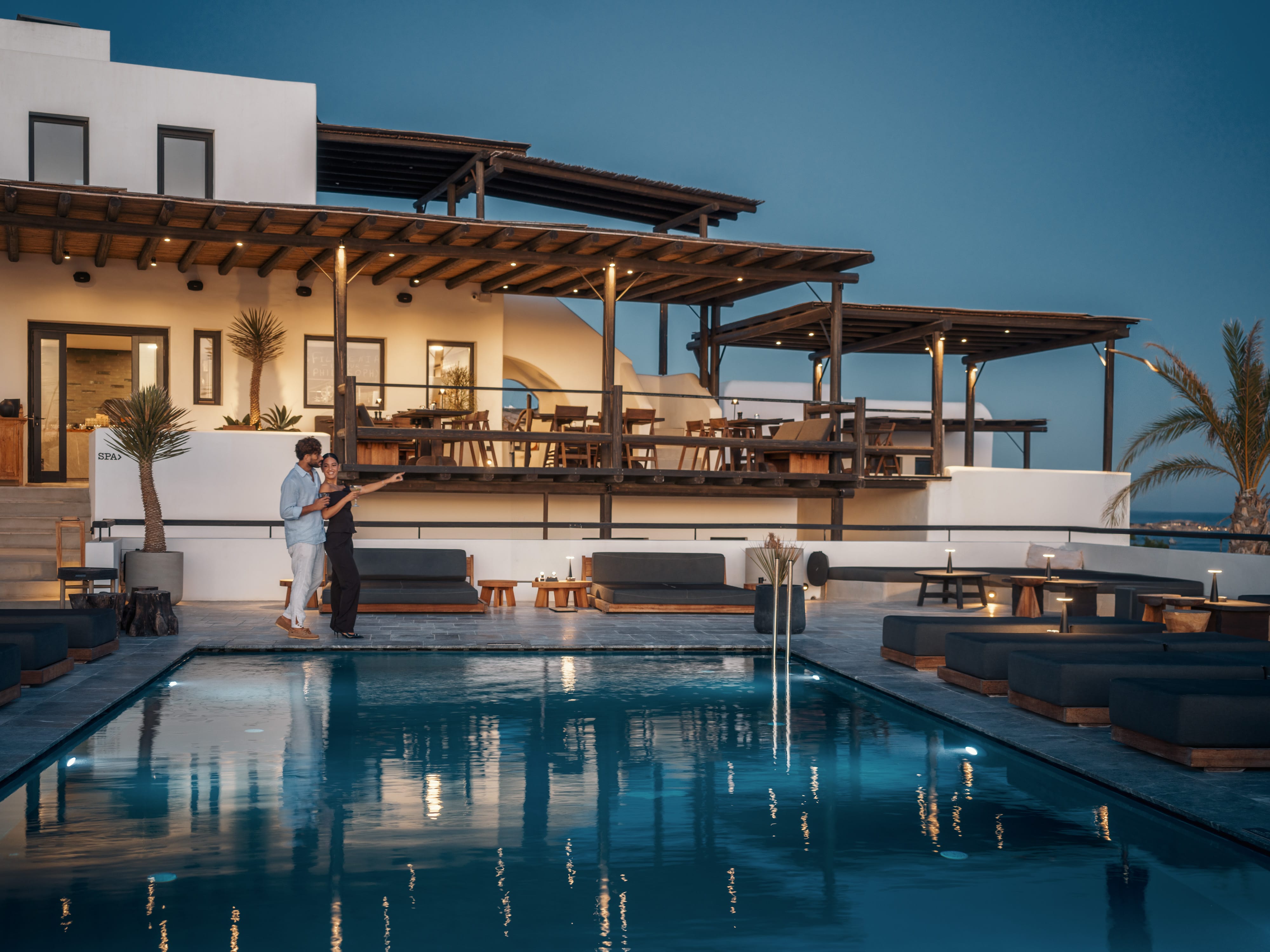 a couple of men standing on a dock by a house