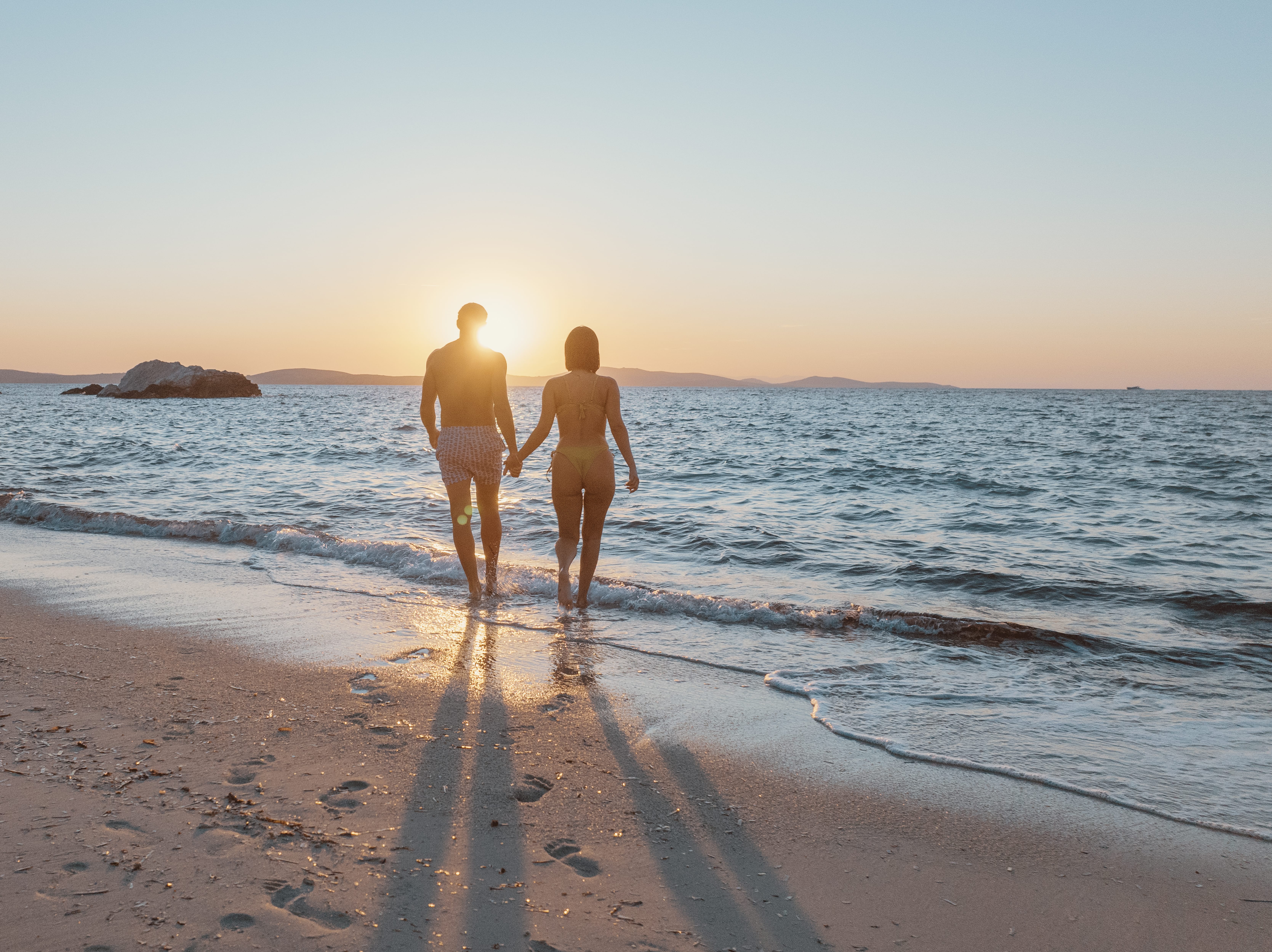 a man and woman walking on a beach