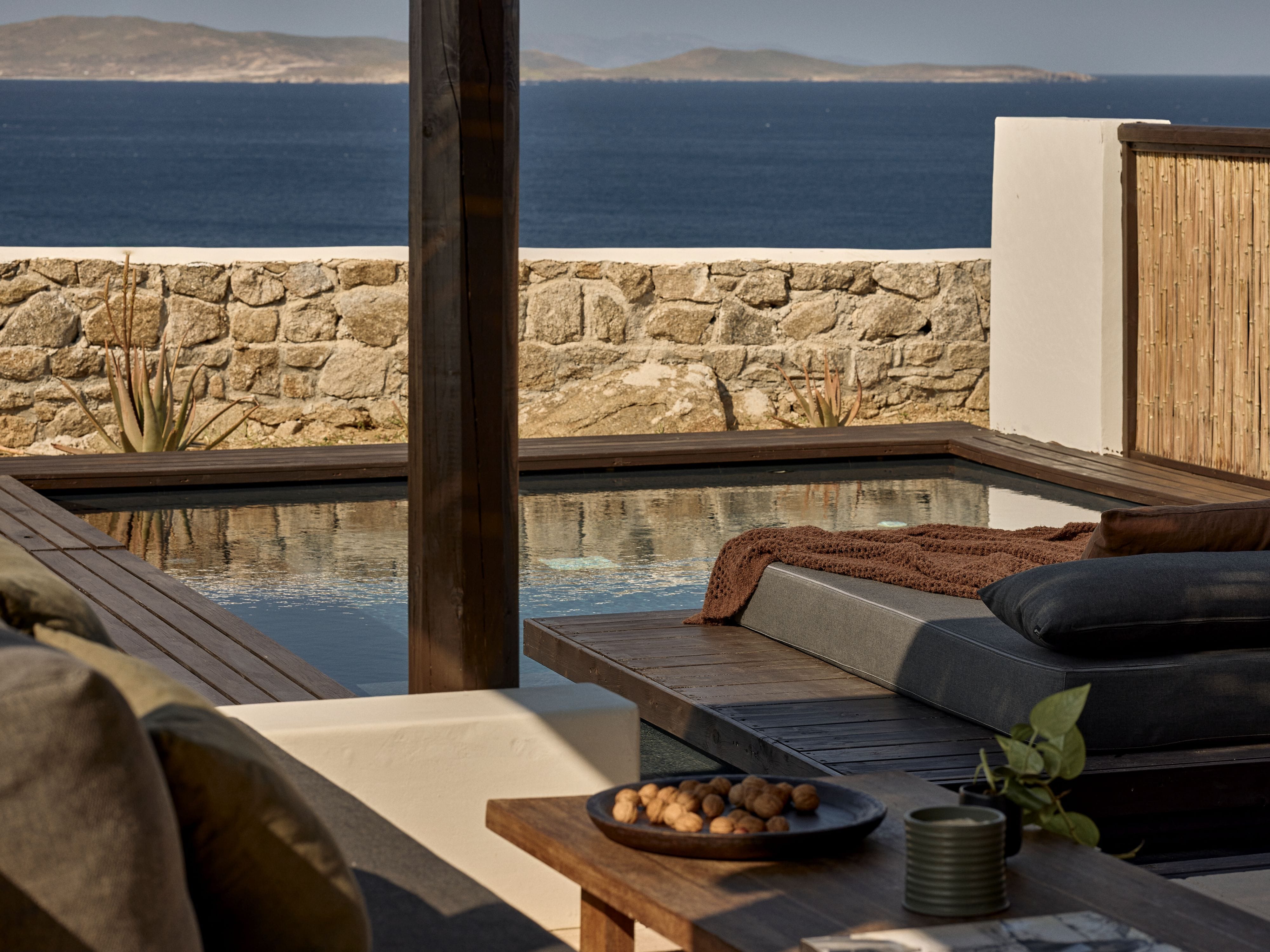 a deck with a view of the ocean and a rocky cliff