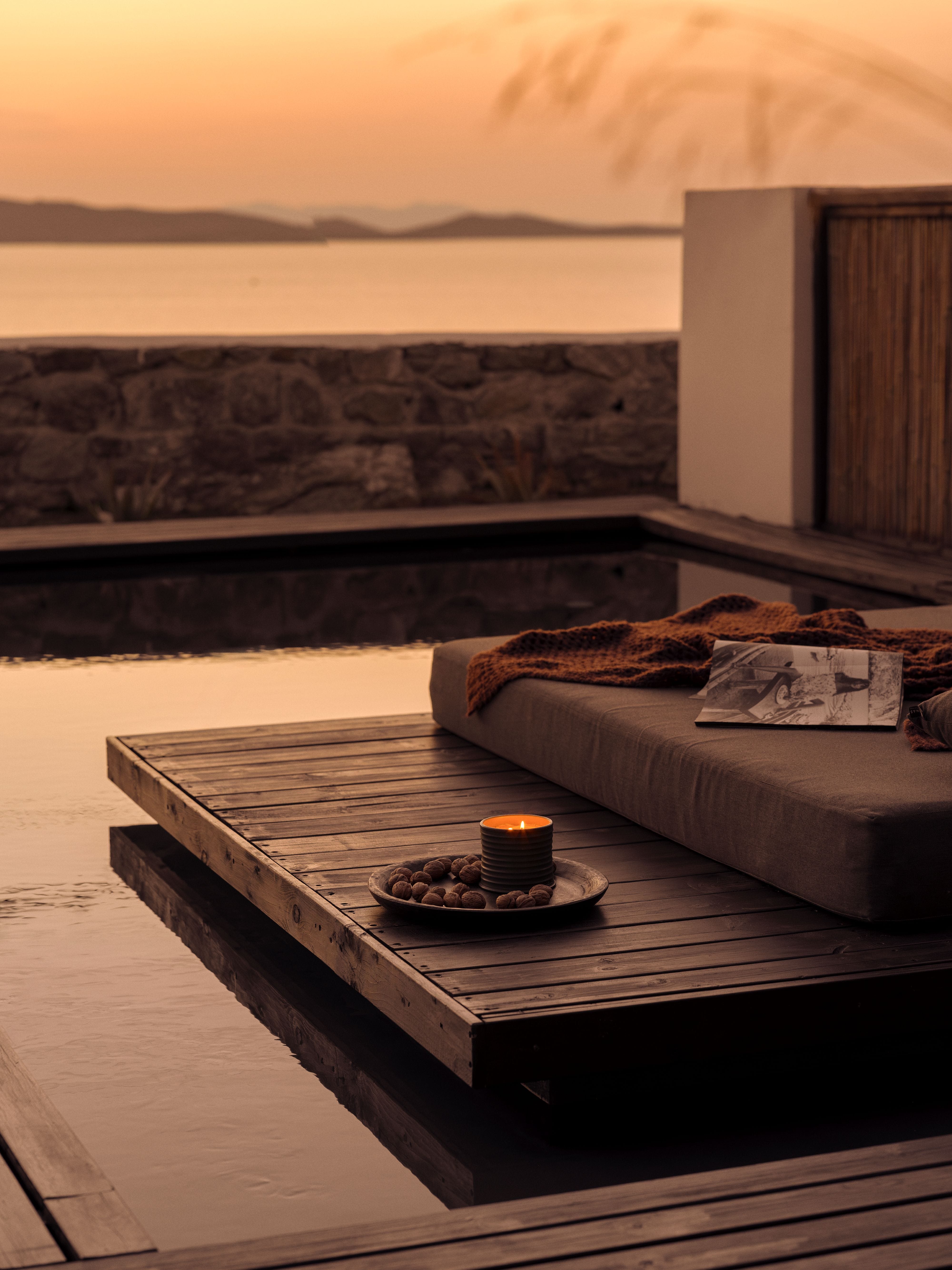 a table with a candle on it by a body of water
