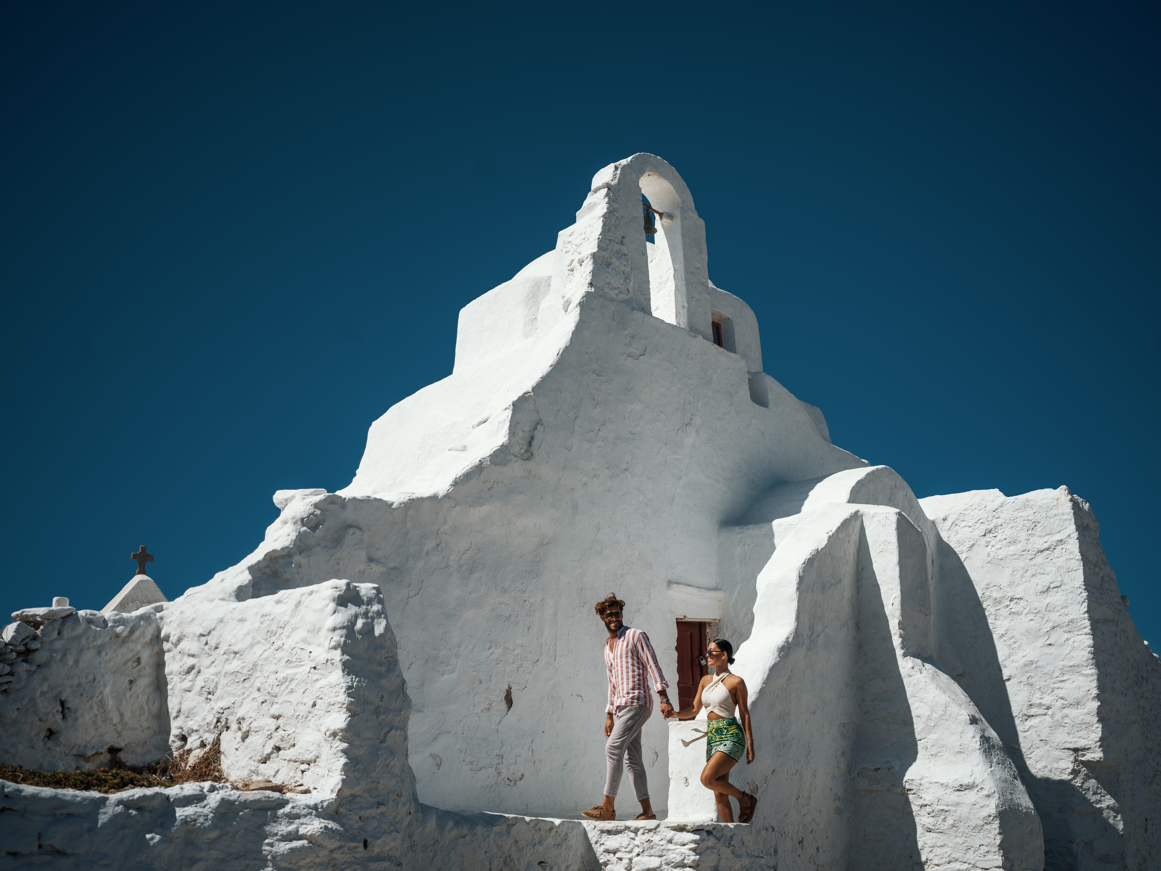 a man and woman standing in front of a large white building