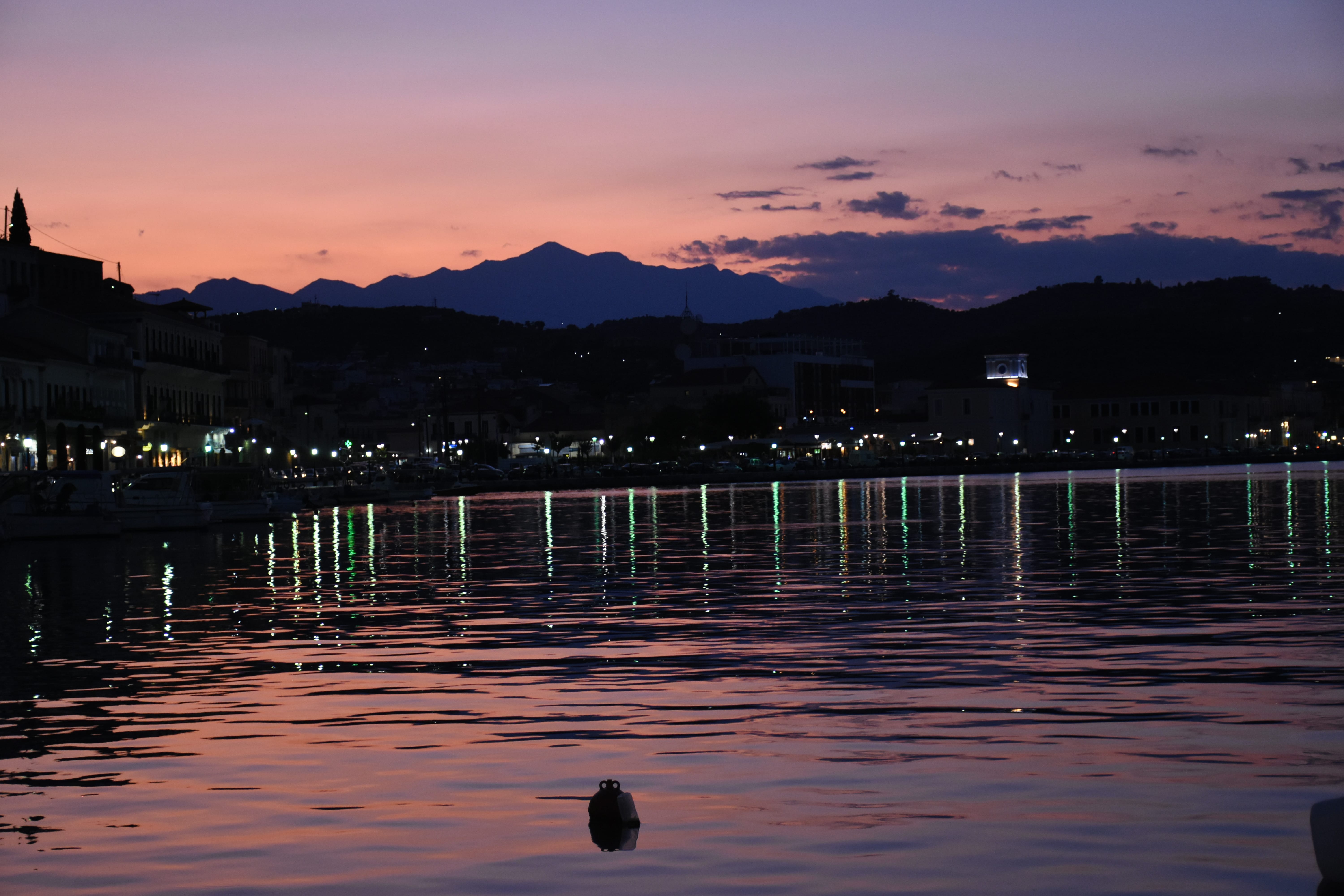 a body of water with a dock and a city in the background