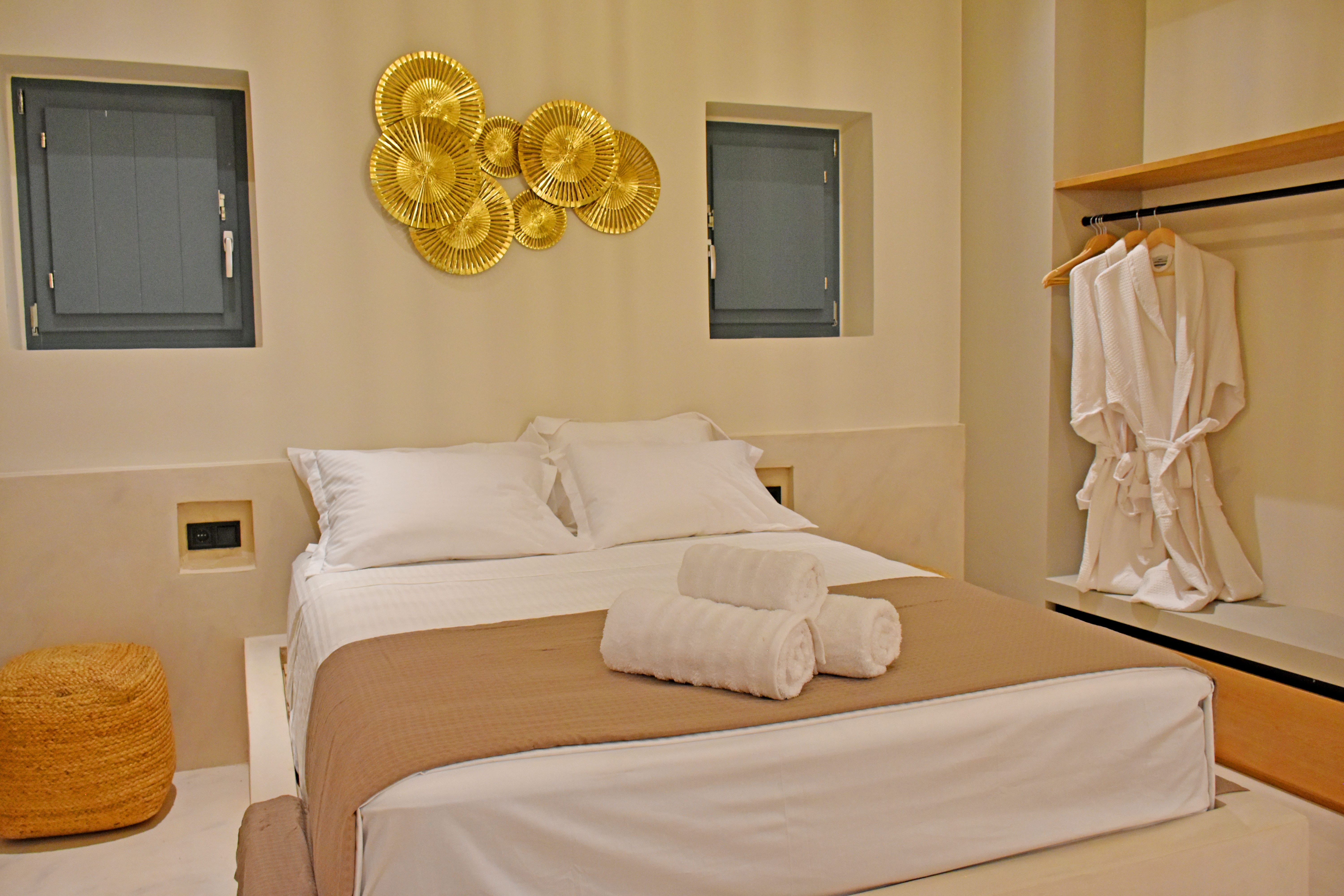 a bed with white sheets and a white towel on the wall