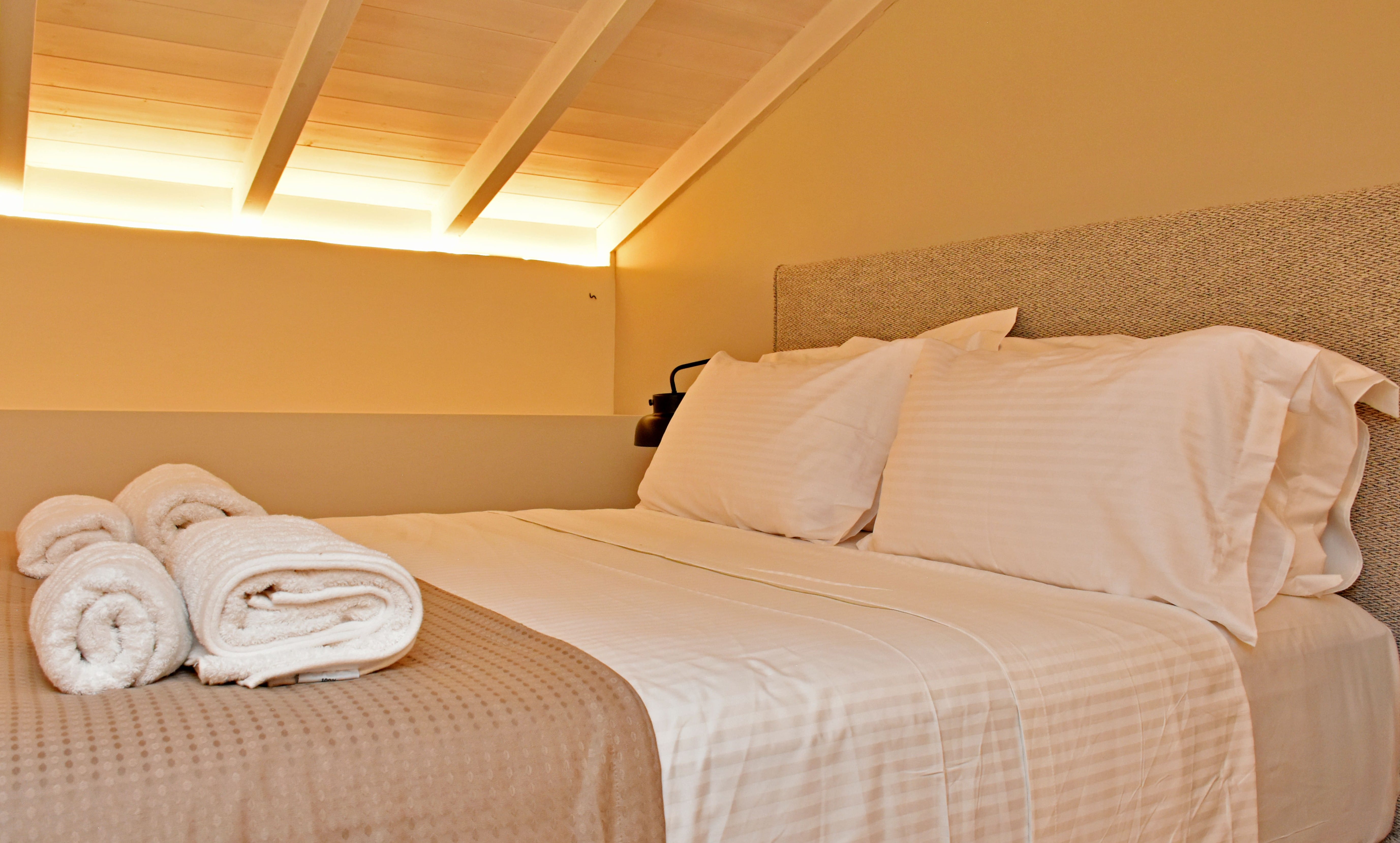 a couple of beds with white sheets