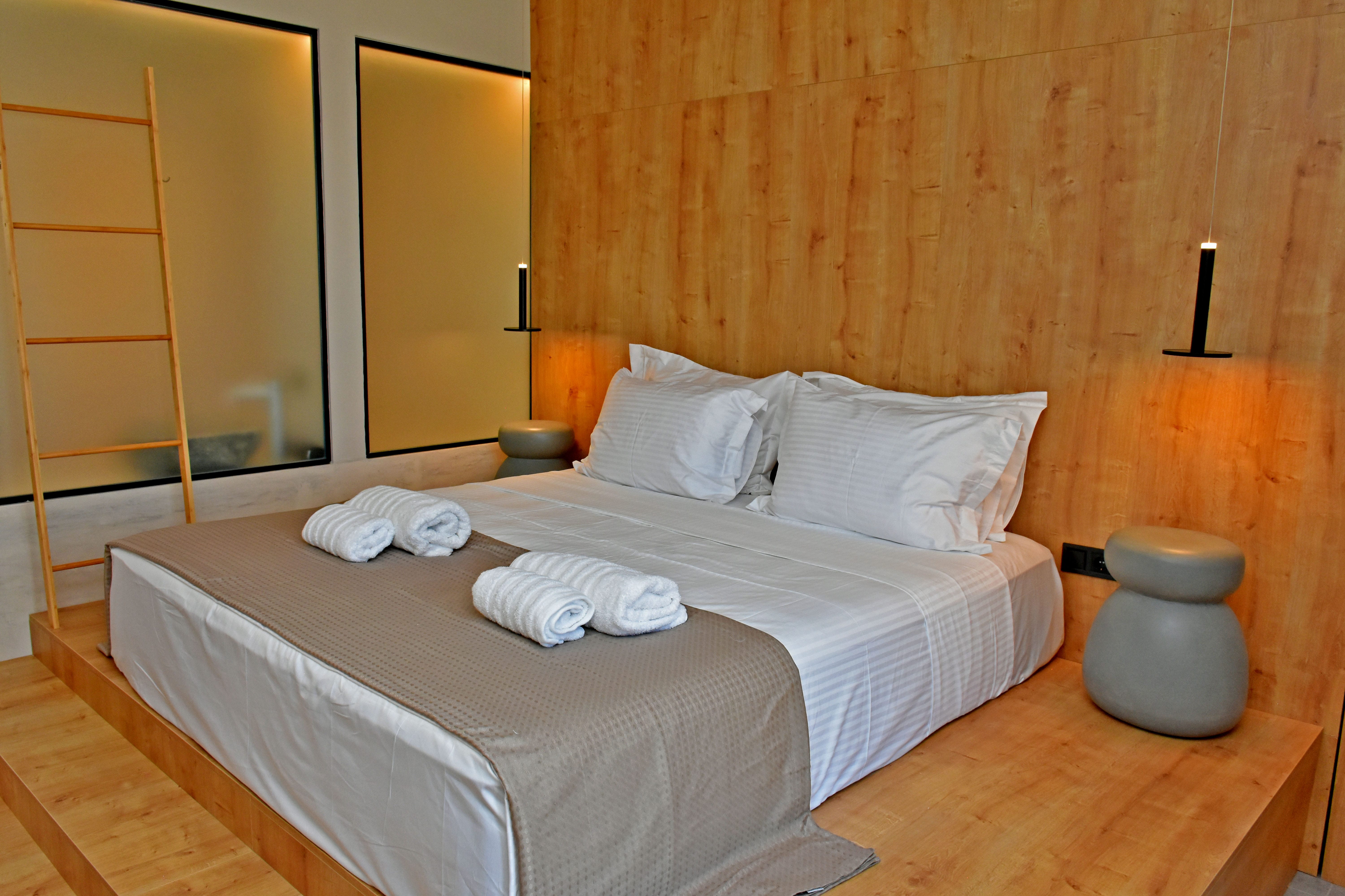 a bed with white sheets and towels