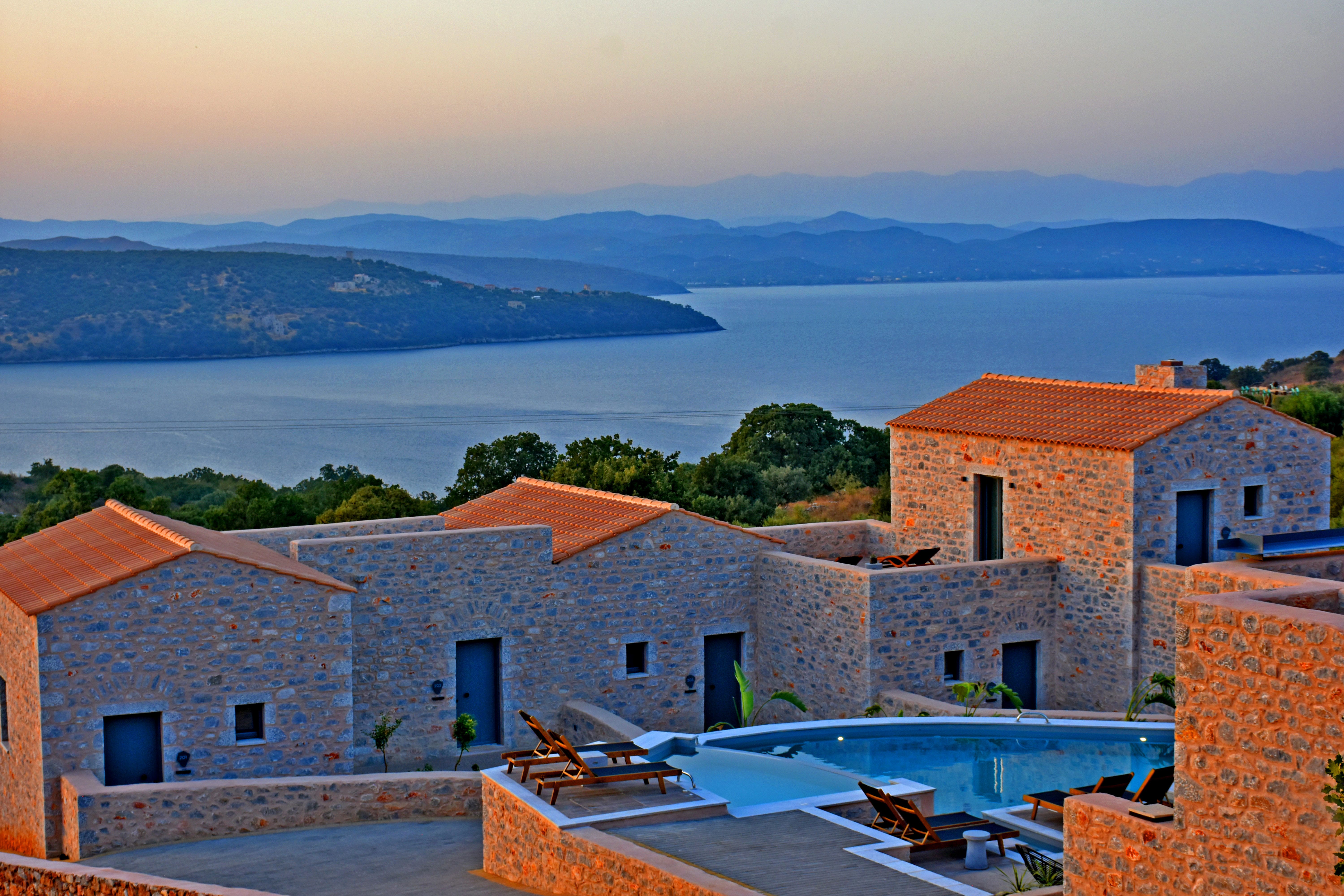 a group of buildings with a body of water in the background