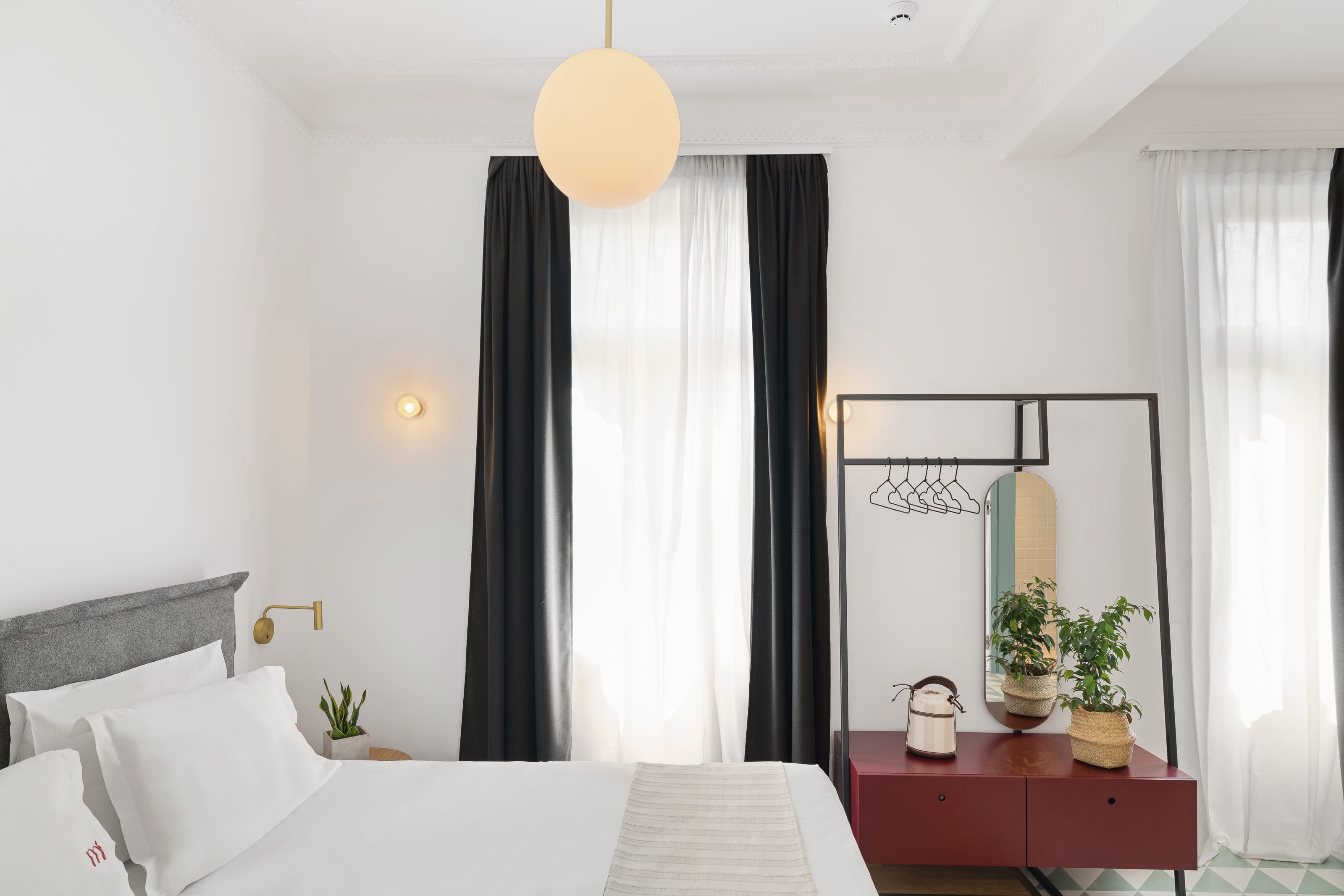 a room with a bed and a window with a lamp on it