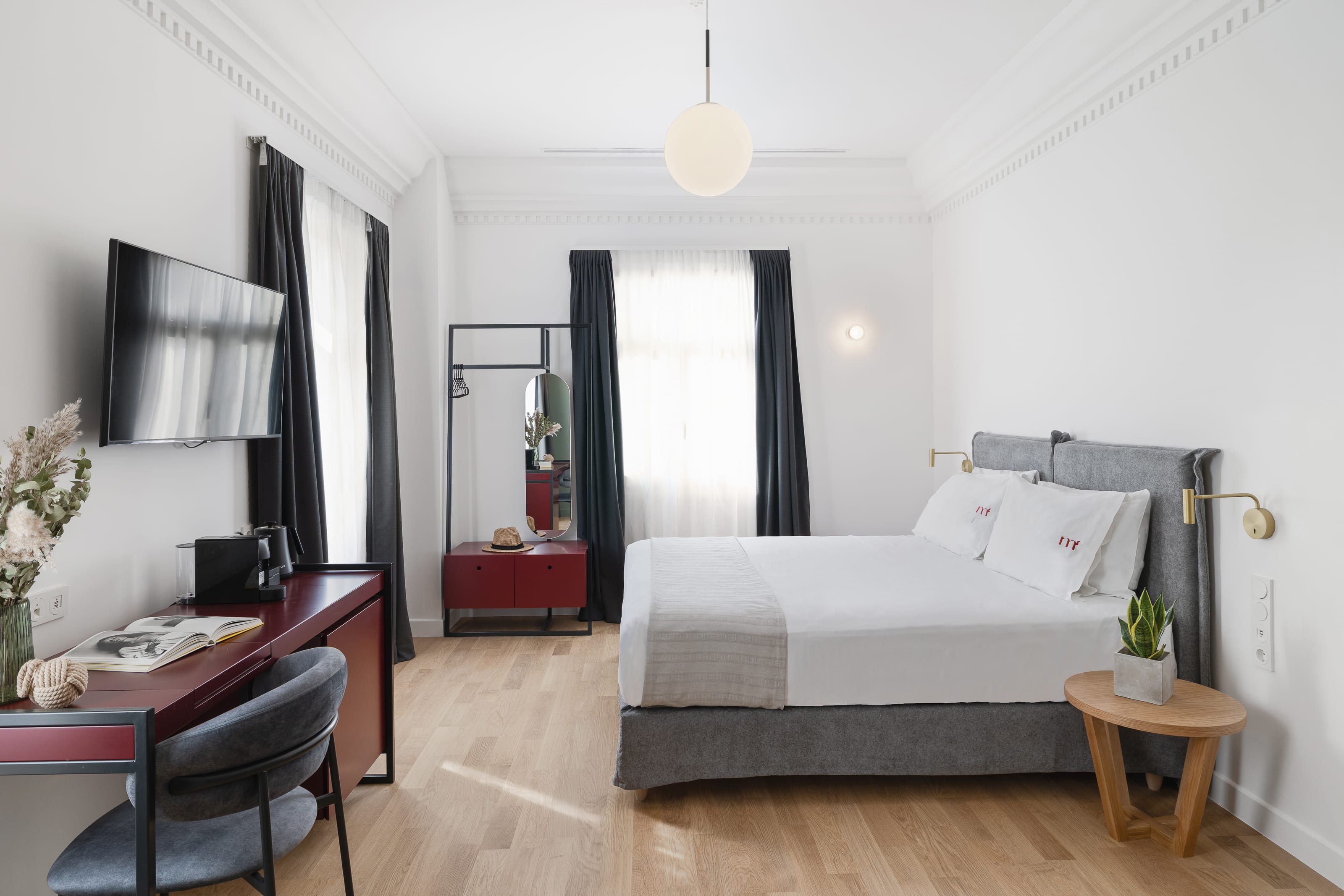 a bedroom with a bed desk and a mirror