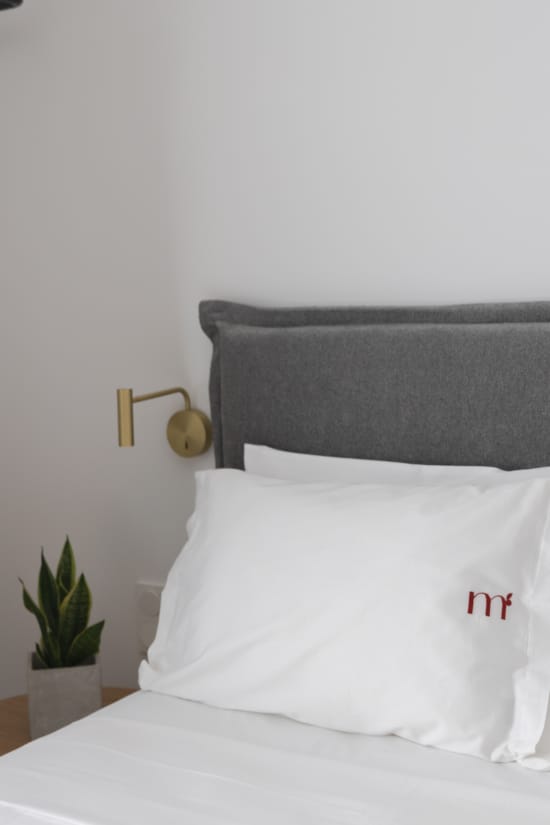 a bed with a white pillow