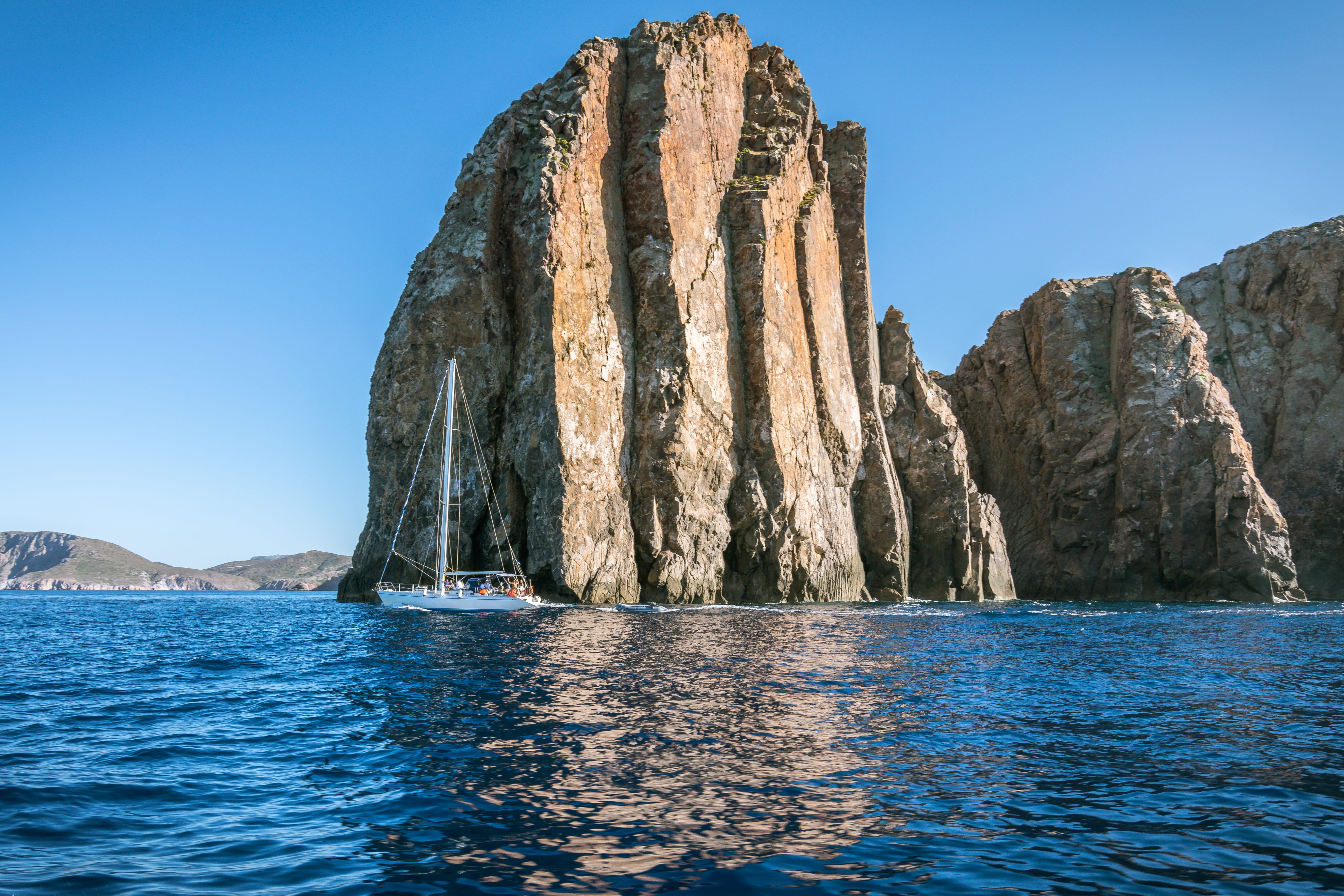 a boat in the water by a rock formation
