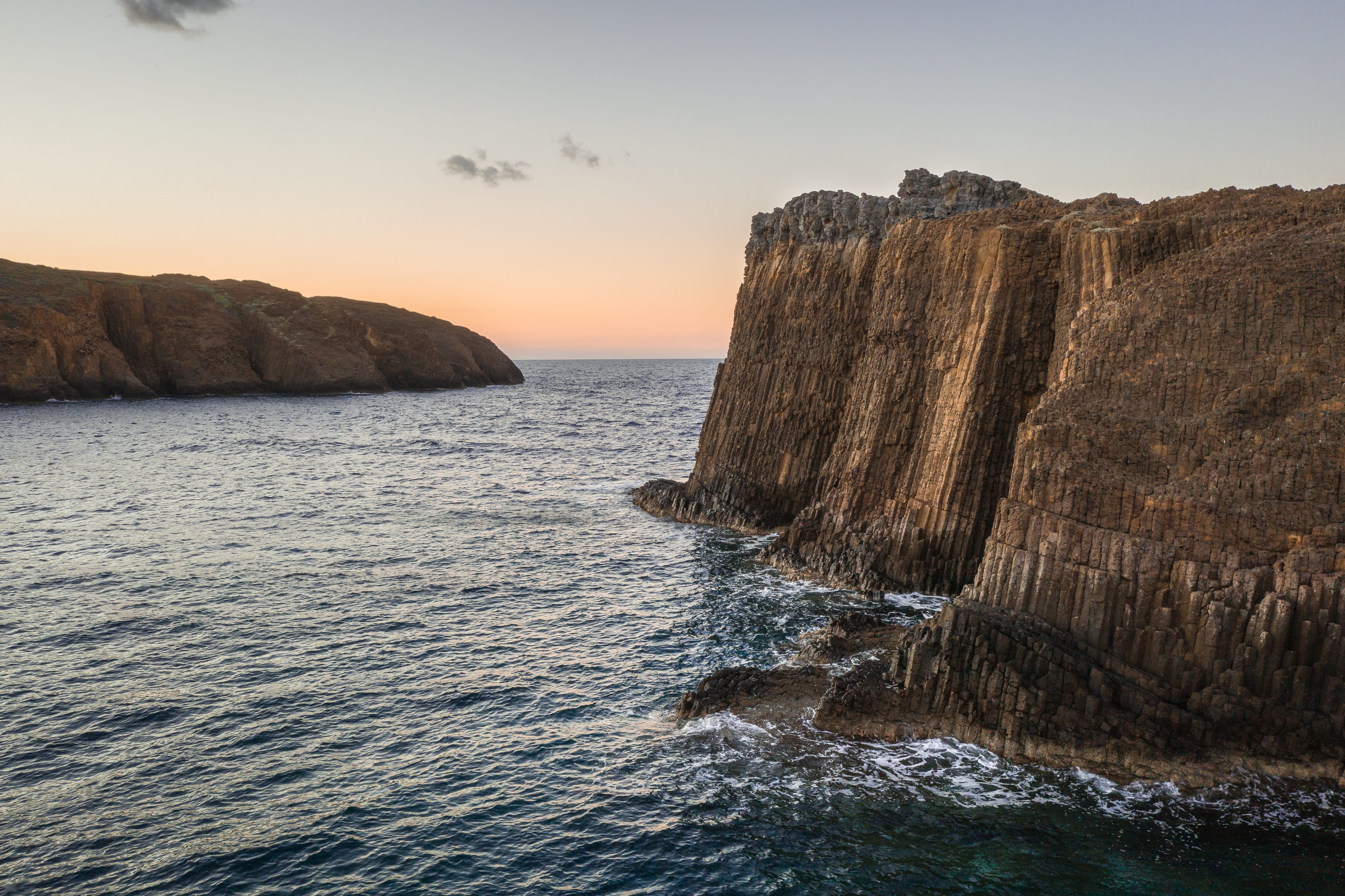 a rocky cliff next to the ocean