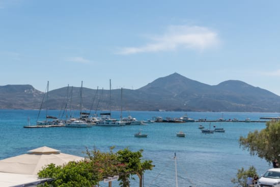 a body of water with boats in it and mountains in the background