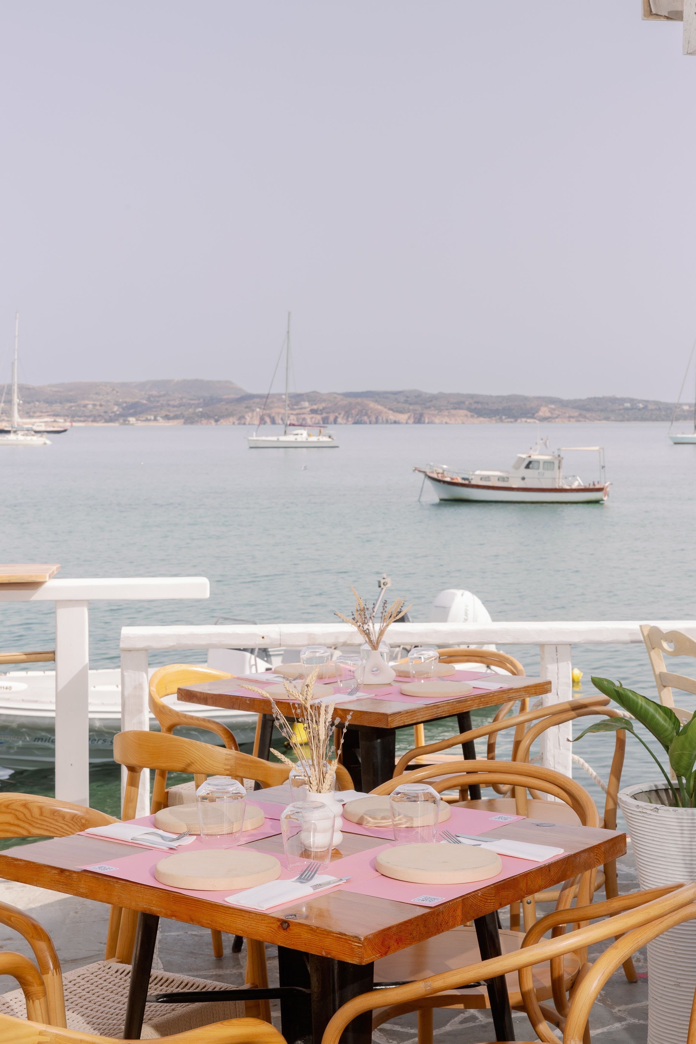 a table with plates and glasses on it by a body of water