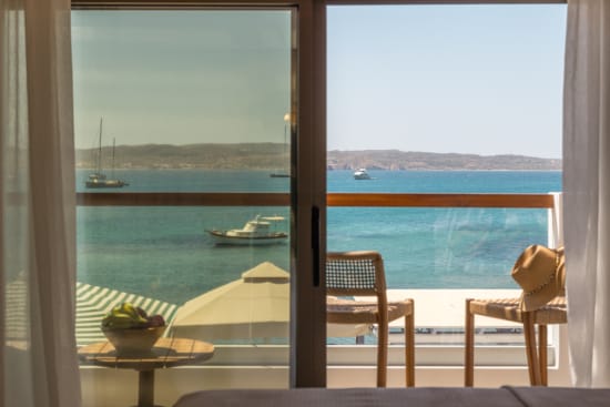 a table and chairs in front of a window overlooking a body of water