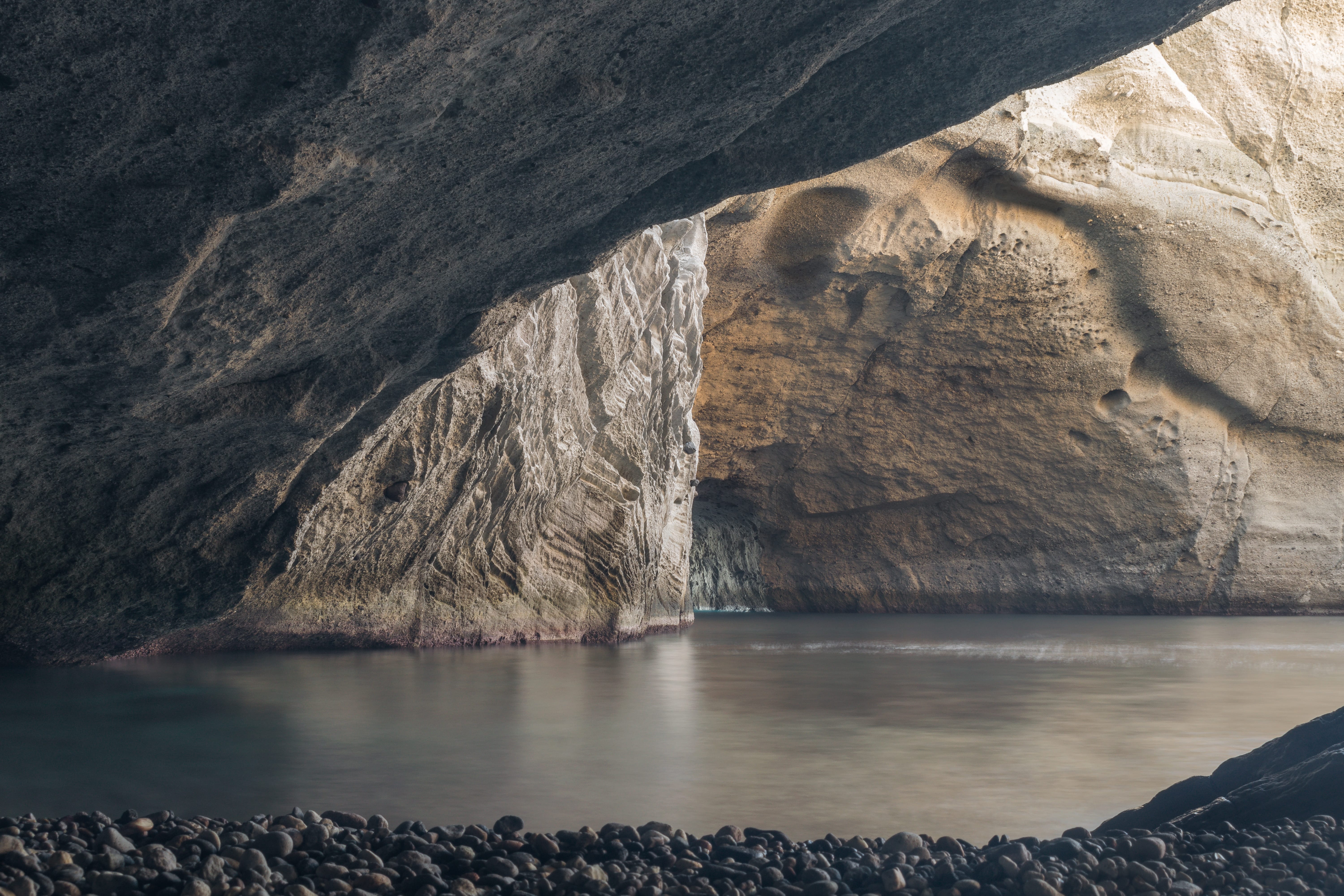 a body of water with a rocky cliff in the background