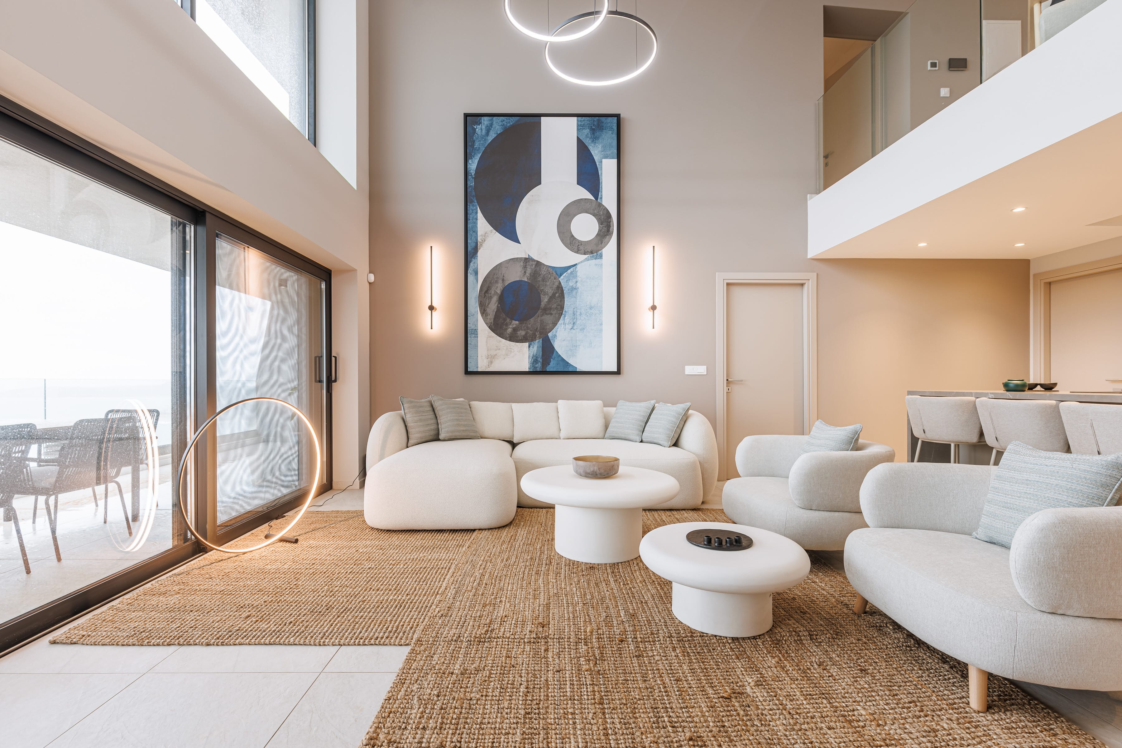 a room with white couches and a large painting on the wall