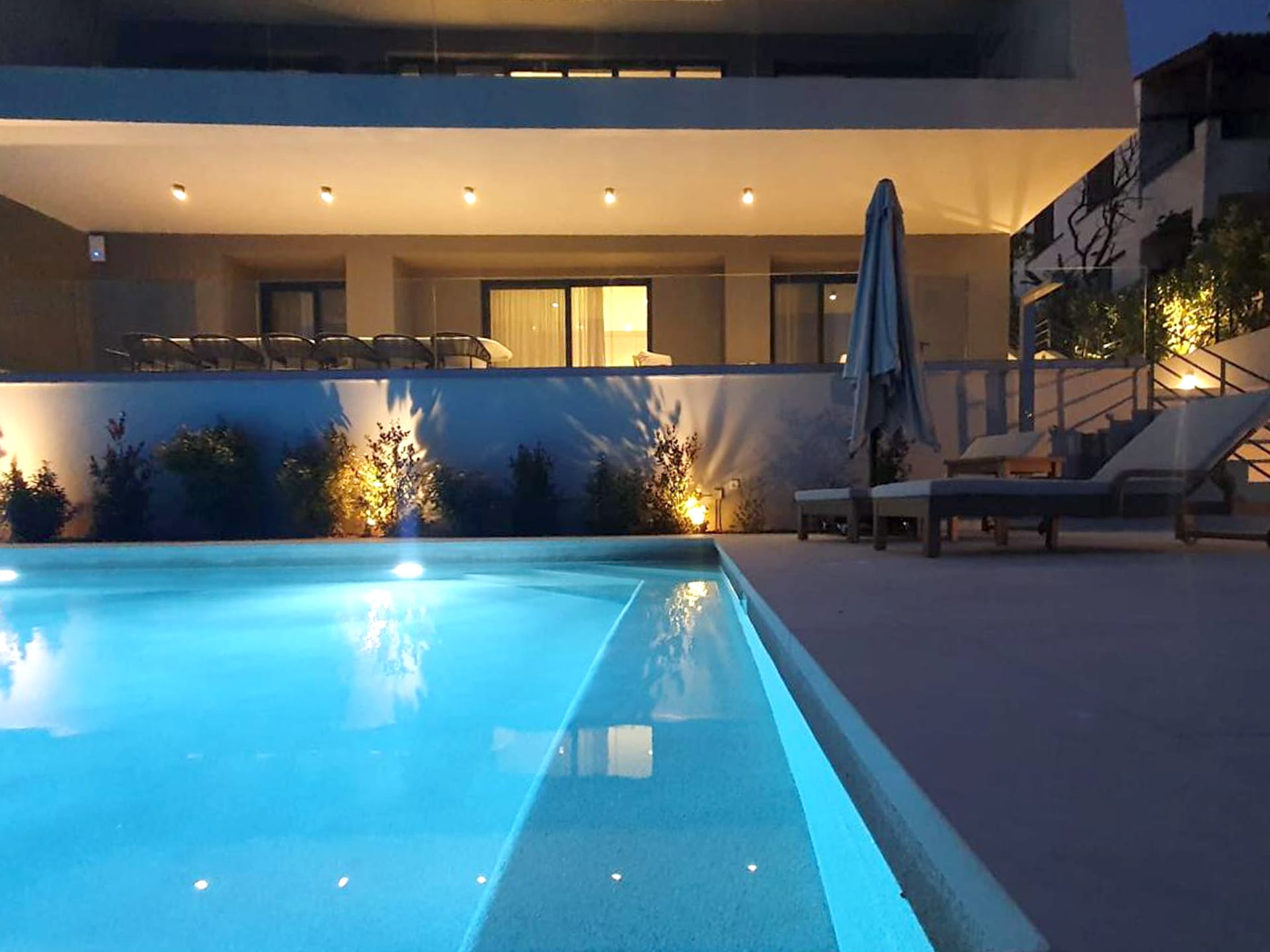 a pool with a deck and chairs in the back