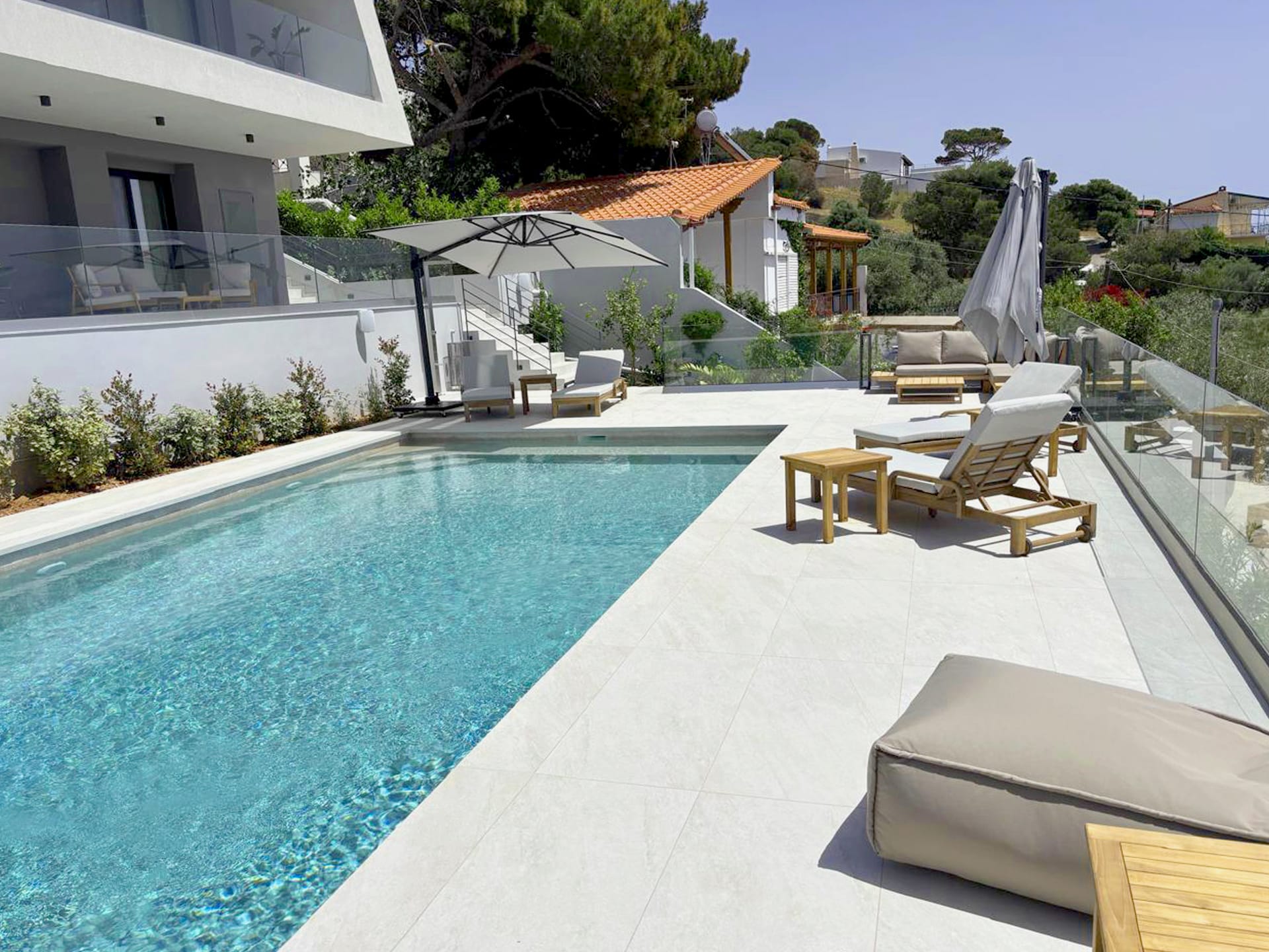 a swimming pool with lounge chairs and umbrellas