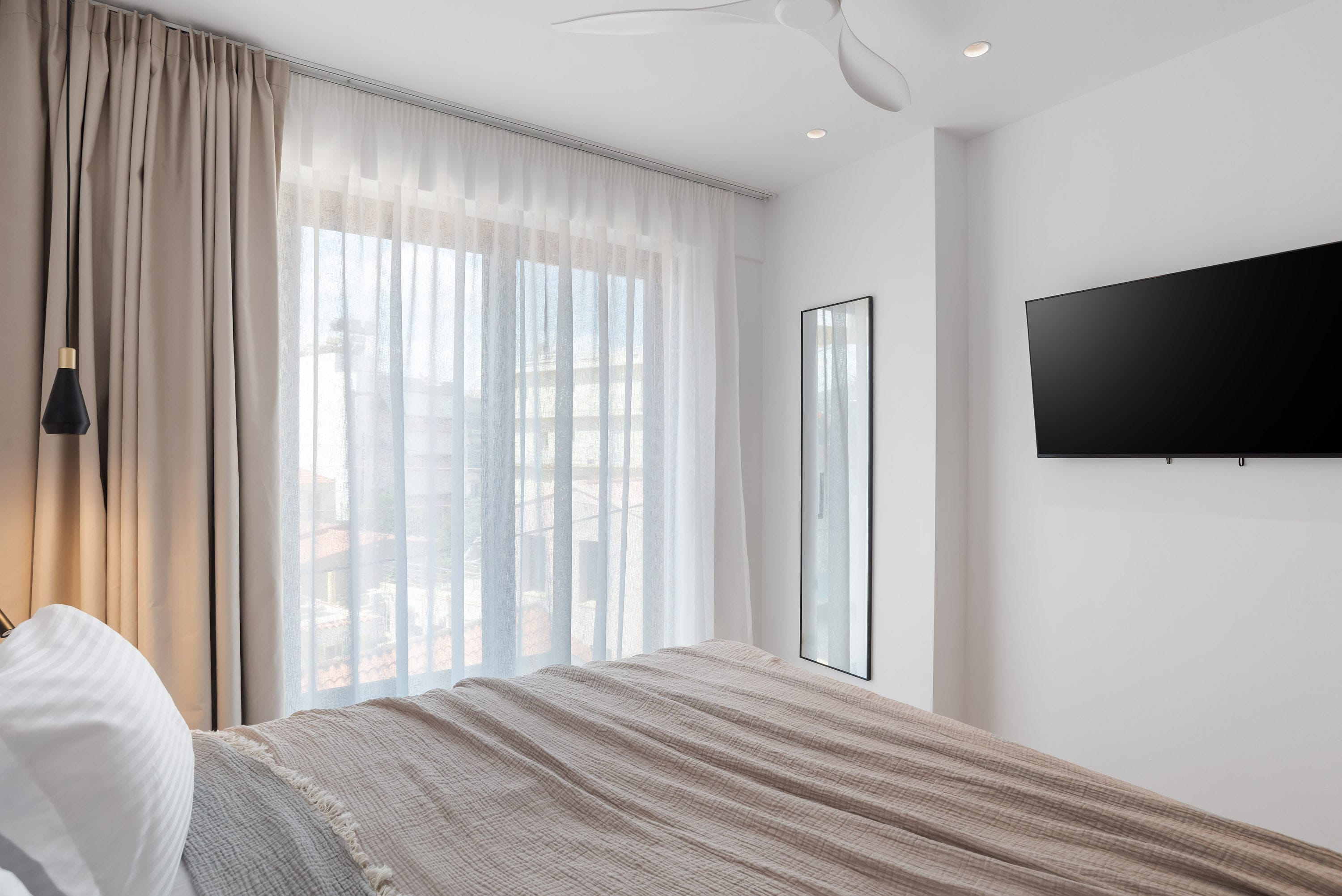 a bed with a television on the wall