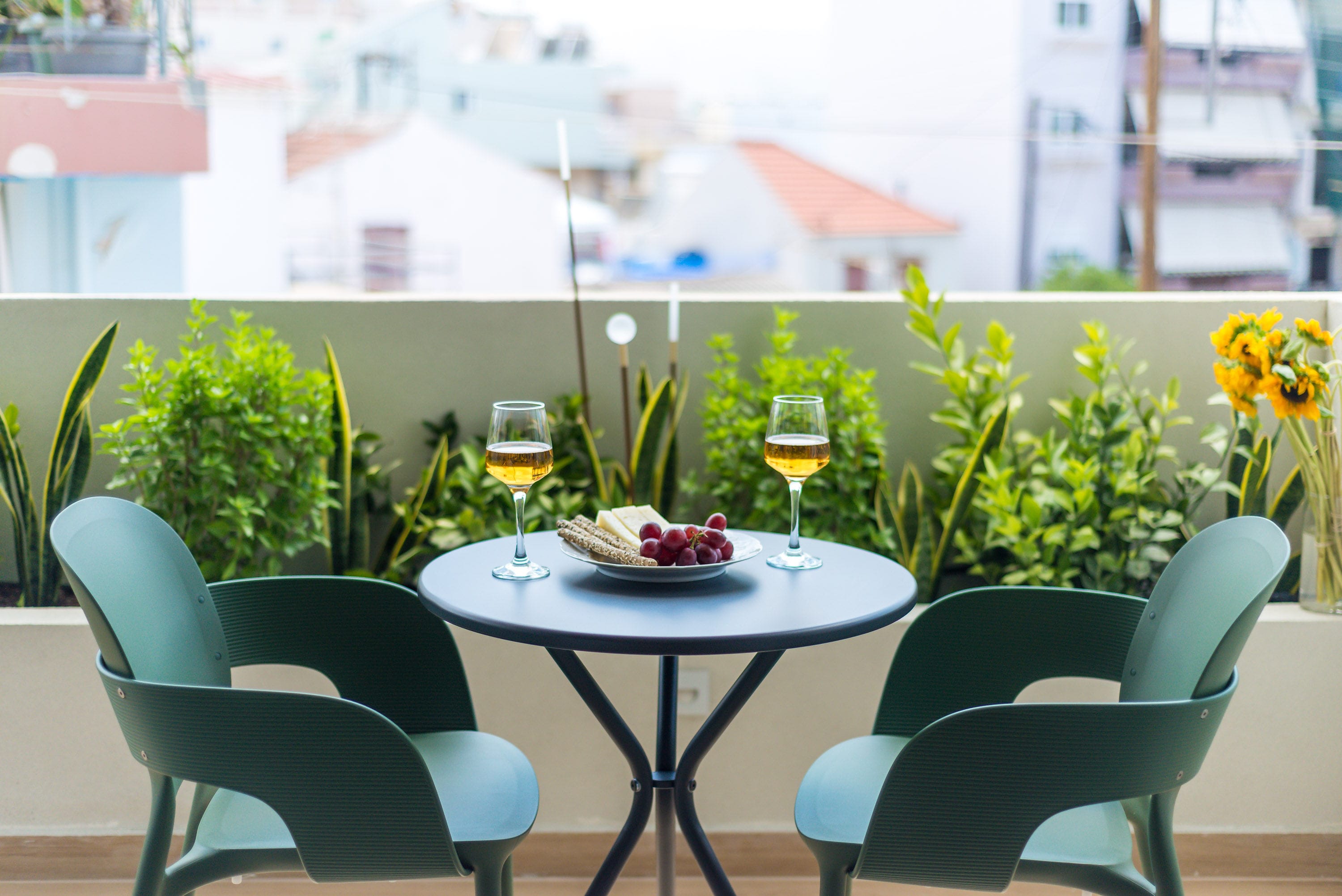 a table with glasses of wine on it and plants around it